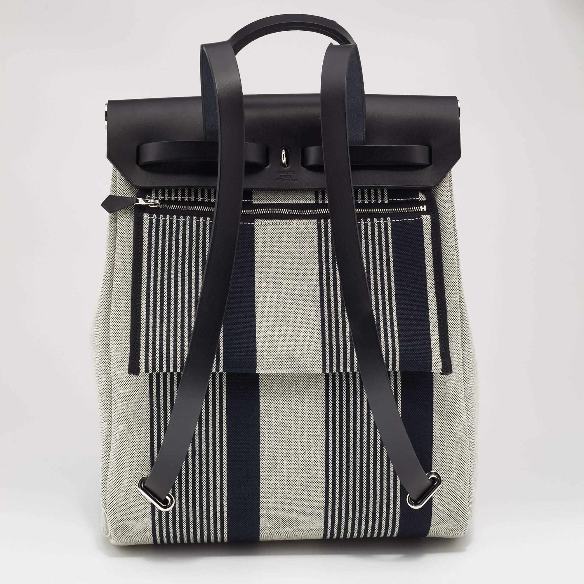 The Hermès Herbag backpack is a stylish and versatile accessory that effortlessly combines functionality with luxury. Crafted with impeccable attention to detail, it features a durable canvas body with supple leather accents. The spacious interior,