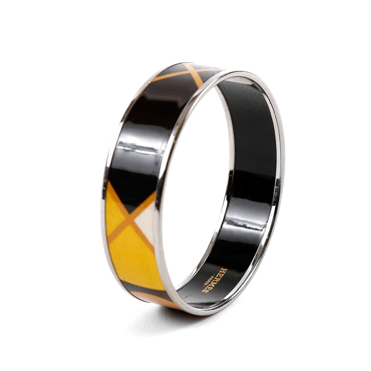 This authentic Hermès Black Enamel X Bracelet is in very good condition. Black enamel bracelet with X design in yellow and orange.  Silver tone edges.   


