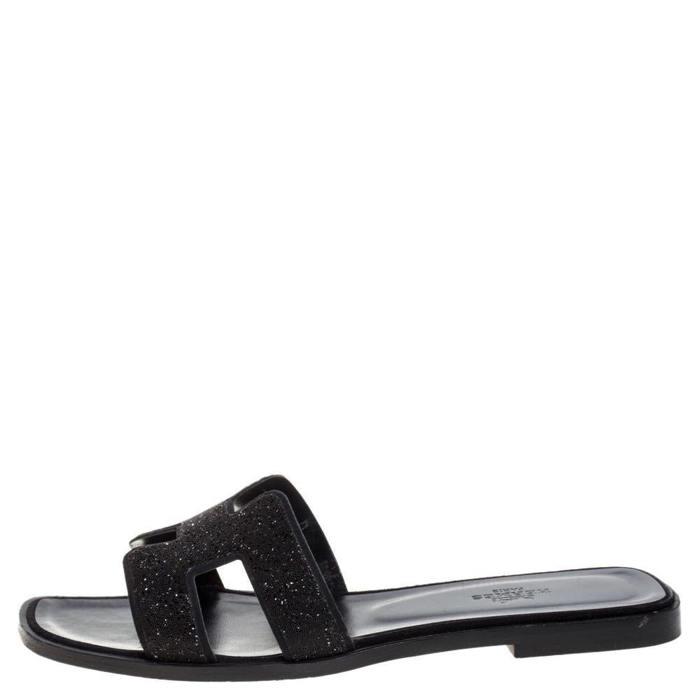 Put your best foot forward this season in these pretty Hermes sandals. These black Oran sandals have been crafted from glitter leather in Italy and they feature the iconic H on the vamps as well as insoles meant to provide comfort at every step.