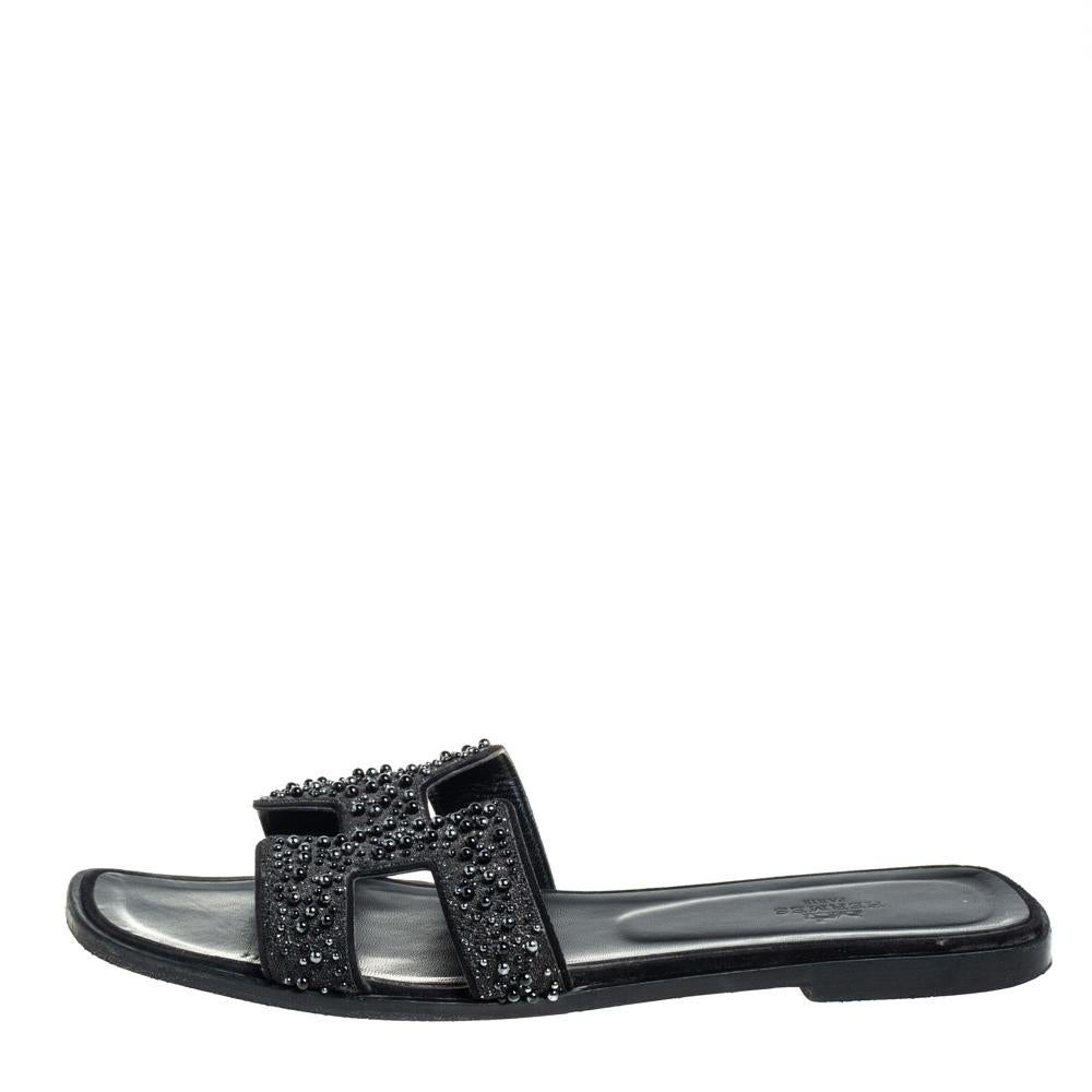 Put your best foot forward this season in these pretty Hermes slides. These black Oran slides have been crafted from embellished glitter suede in Italy and they feature the iconic H on the vamps as well as insoles meant to provide comfort at every