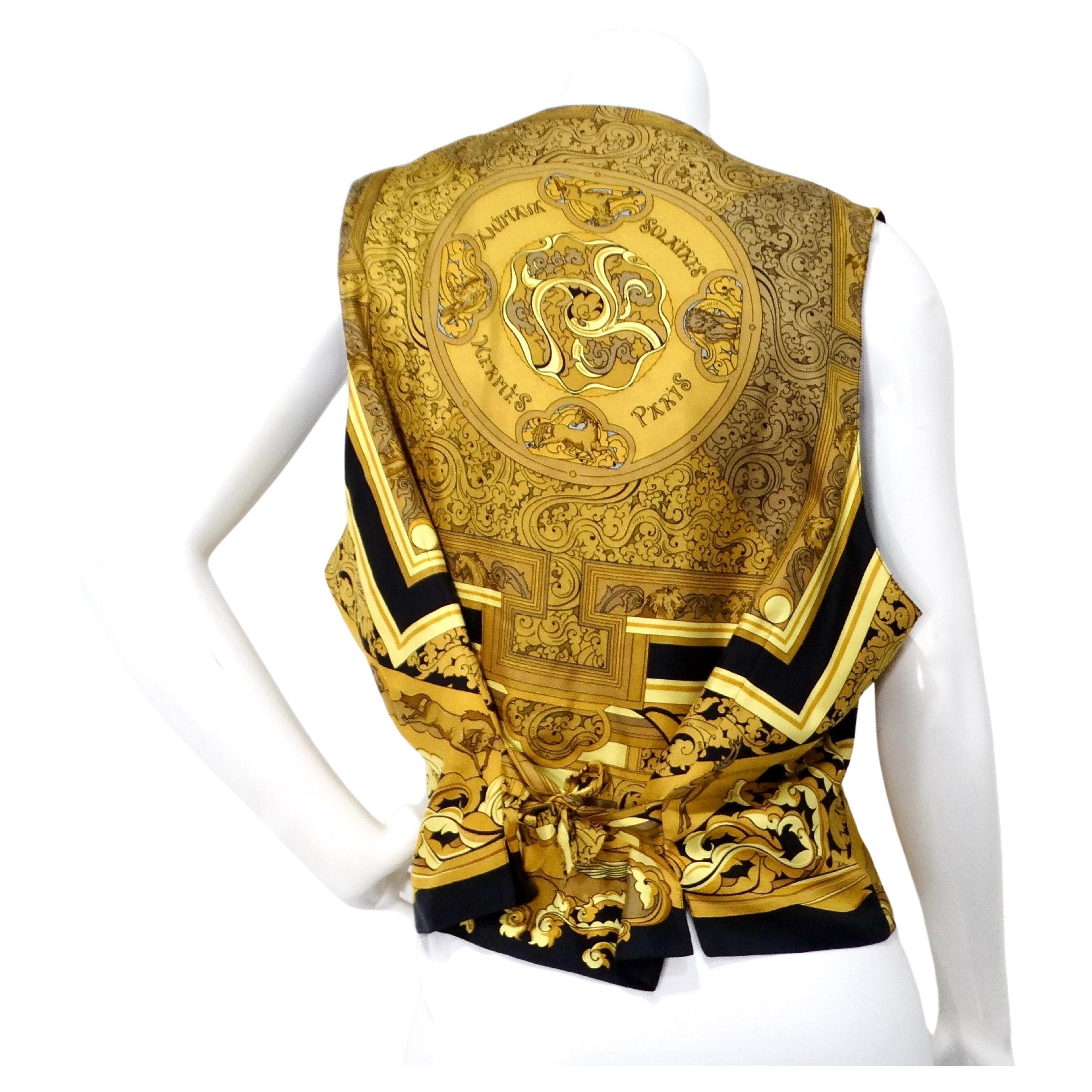 Questo splendido gilet Hermes nero e oro con stampa su seta Des Tuileries, risalente agli anni '90, è un'aggiunta lussuosa e senza tempo a qualsiasi guardaroba. Realizzato in seta di alta qualità, il gilet presenta un'elegante base nera ornata da