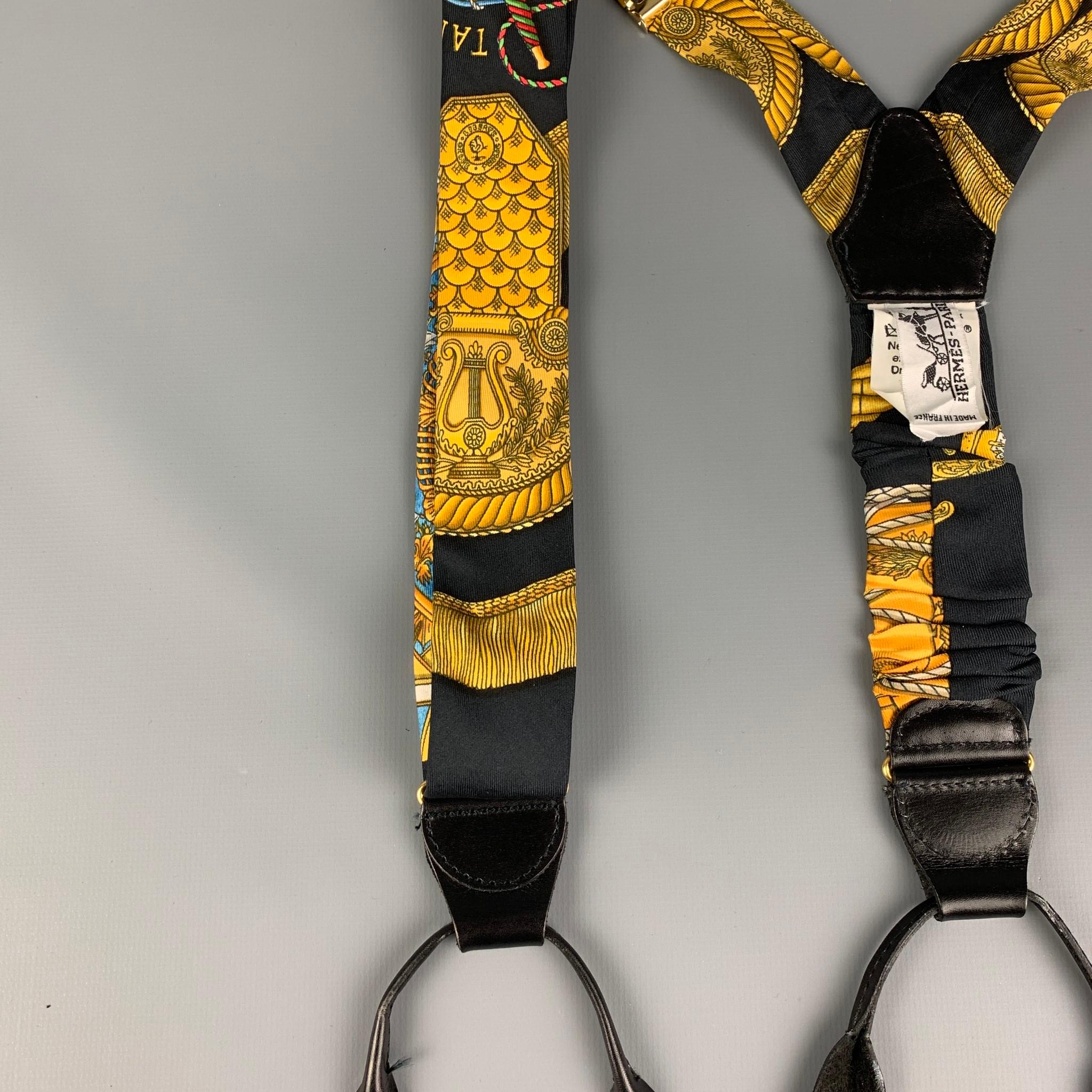 HERMES suspenders comes in a black & gold print  silk featuring a adjustable fit, black leather trim, and includes trouser buttons. Made in France.

Very Good Pre-Owned Condition:

Measurements:

Width: 1.5 in.