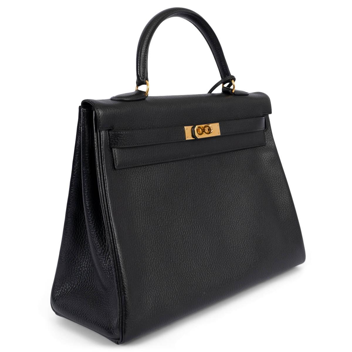 100% authentic Hermès Kelly 35 Retourne bag in black Vache Grainee leather featuring gold-tone hardware. Lined in Chevre (goat skin) with two open pockets against the front and a zipper pocket against the back. Comes with leather shoulder-strap. Has