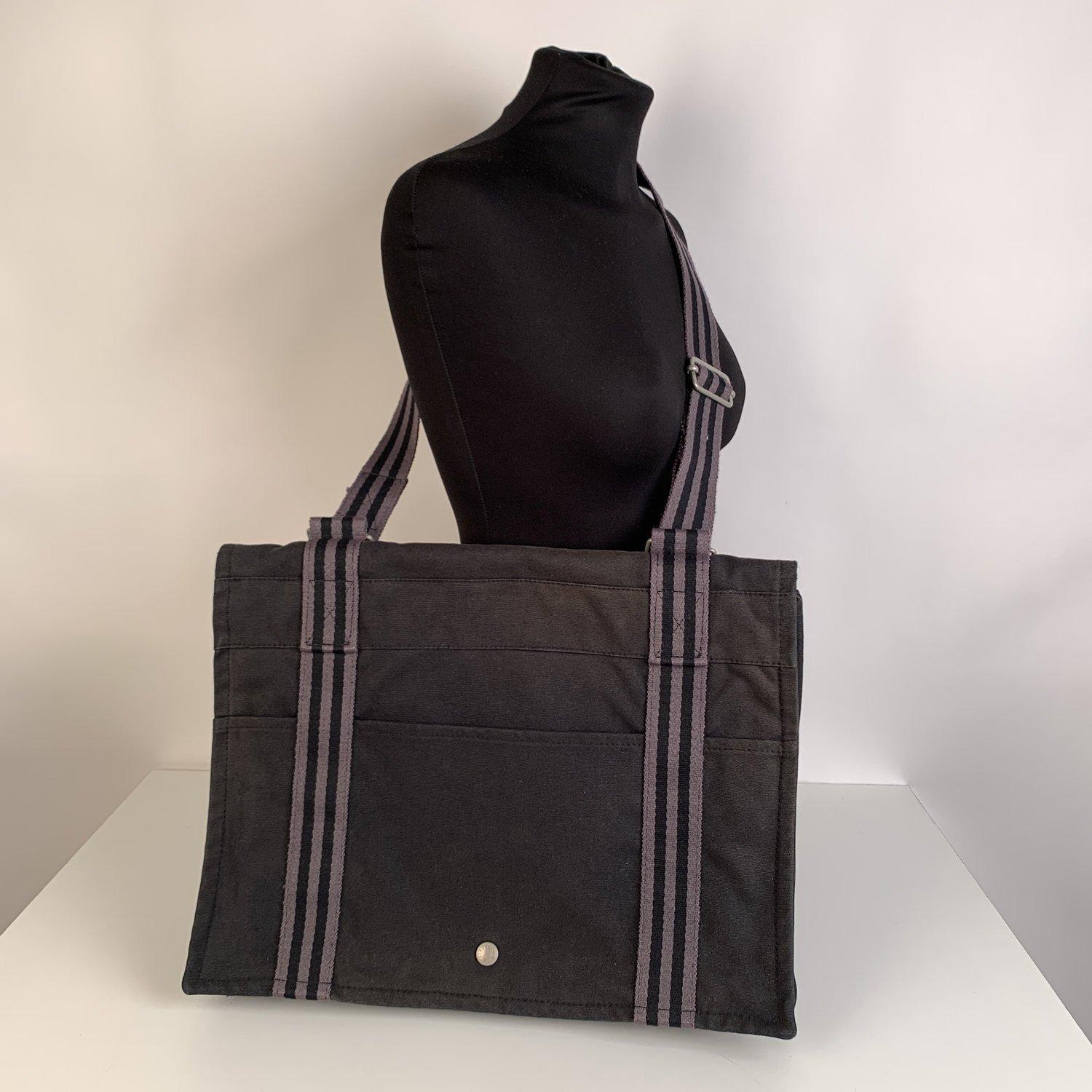 Model: HERMES FOURRE TOUT BESACE Messenger Bag. Made in France. Black and gray colors. Material: 100% cotton. It has snaps on both sides for expansion. 1 open pocket on the front and 1 on the back. Durable canvas adjustable shoulder strap. Flap with