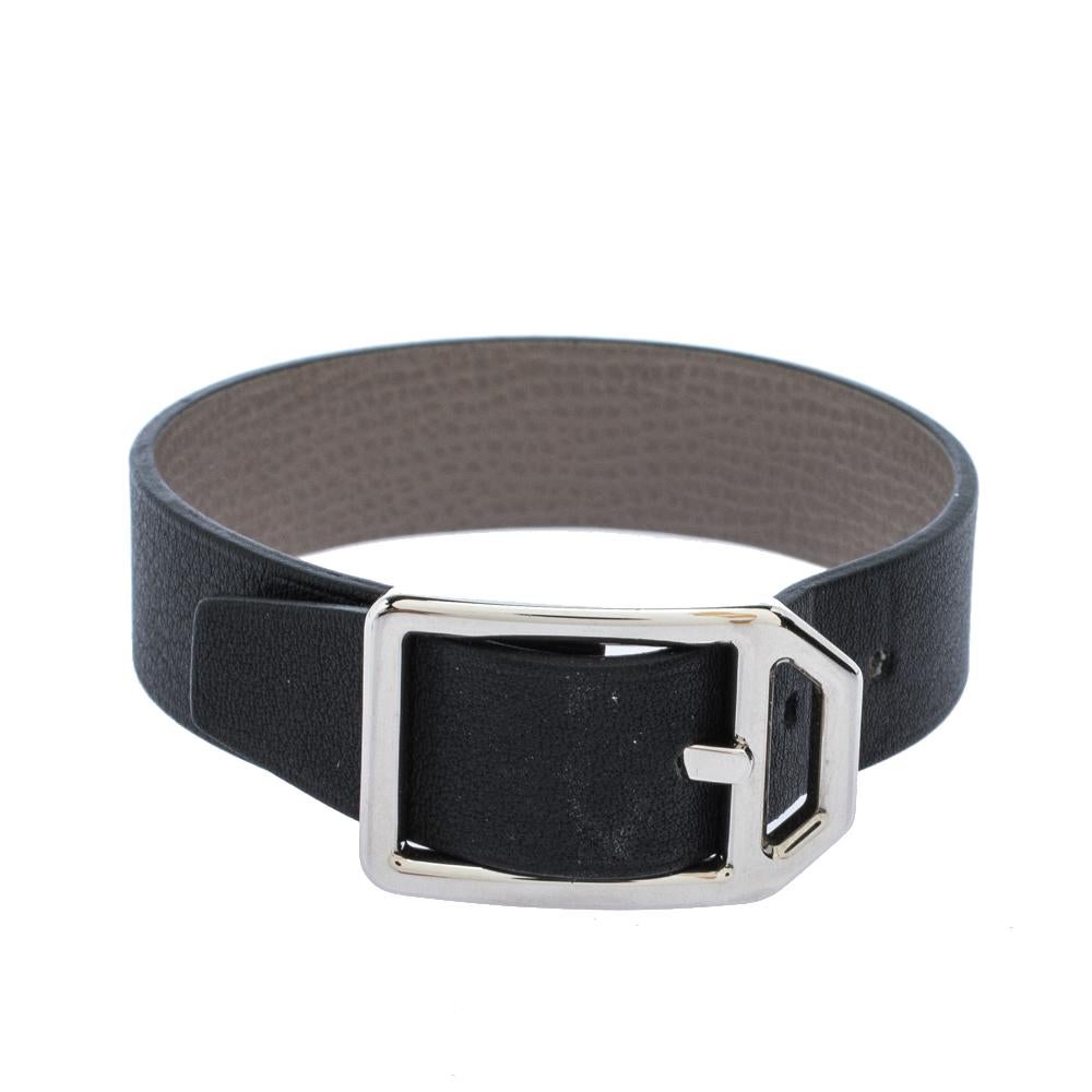 Designed in black and grey leather, this Paddock Simple Tour bracelet is a loved design from the house of Hermes. This bracelet has a palladium-plated buckle and adjustable holes for the correct fit.


