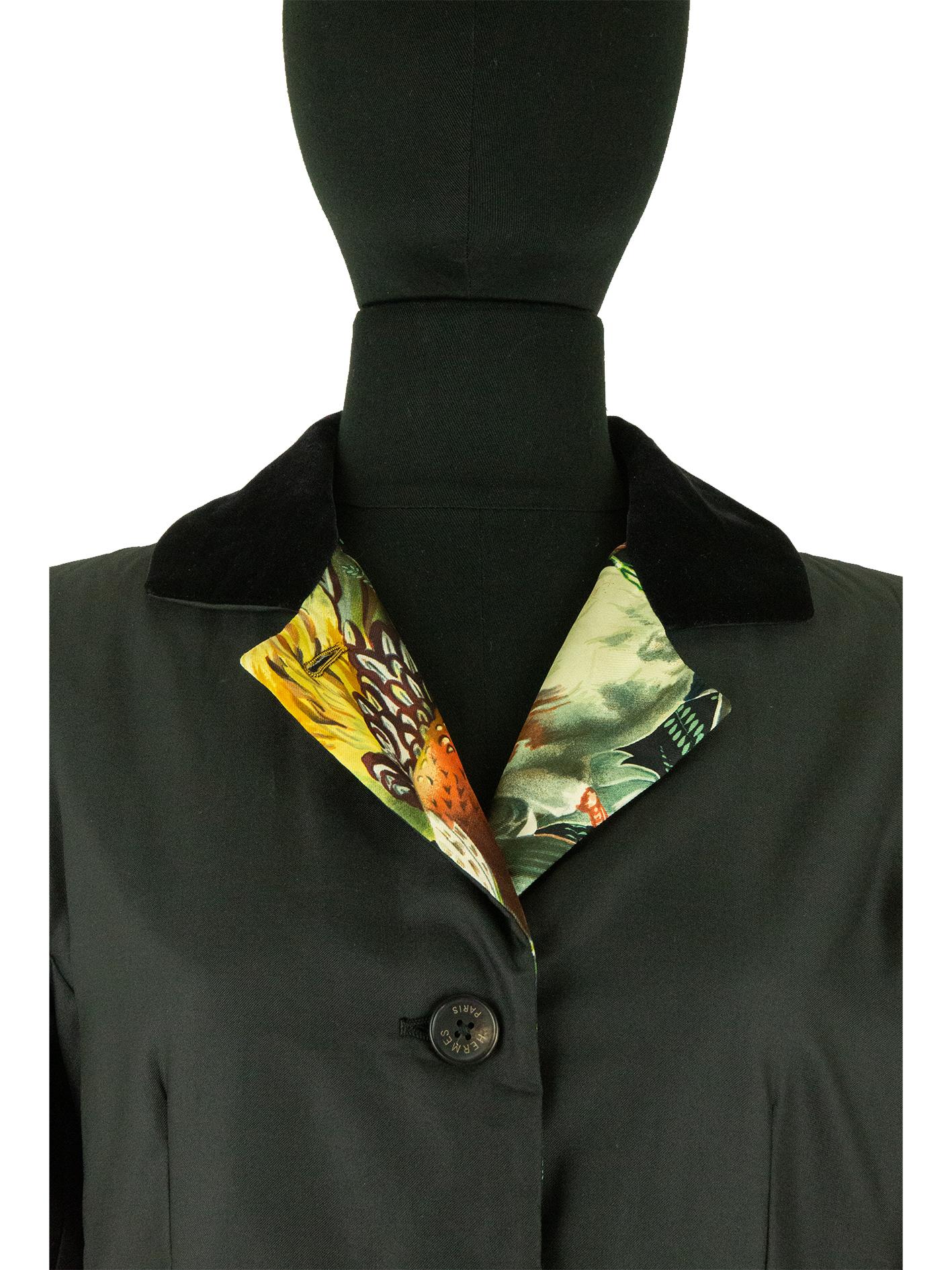 Cette longue veste noire d'Hermès comporte de nombreux détails. Les coutures de confection permettent à la veste de s'adapter au corps sans avoir recours à des pinces excessives. Sur le devant de la veste se trouvent deux poches à rabat qui