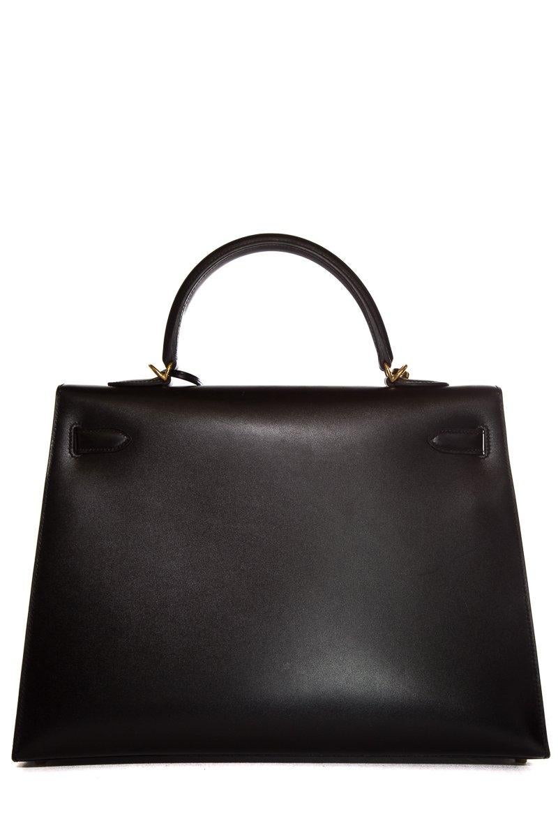 Hermès black swift leather 35cm Kelly Sellier with gold-tone hardware, single rolled top handle, single optional flat shoulder strap, three interior pockets; one with zip closure at back, tonal leather lining and turn-lock closure at front