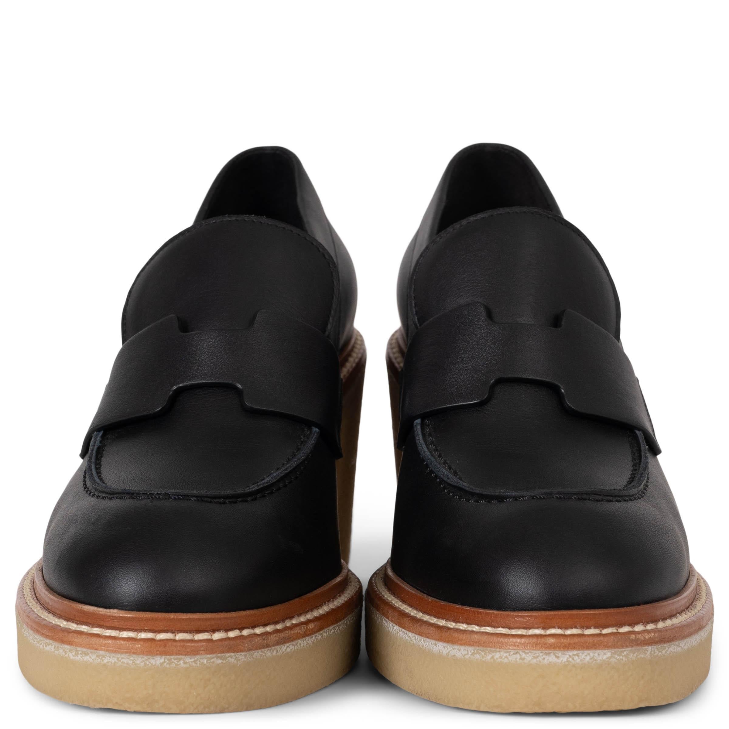 This 100% authentic Hermès Didi 70 loafer pumps in black leather effortlessly blend elegance with contemporary style. Featuring a signature H strap across the front, rounded toes, and camel leather trim with contrasting white stitching, these pumps