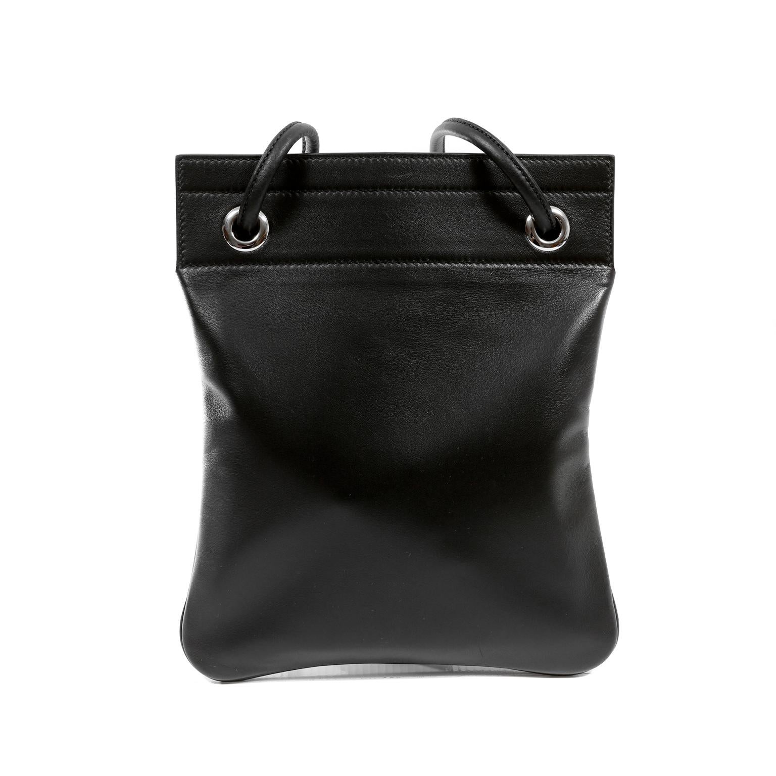 This authentic Hermès Black Leather Aline Mini Bag is in pristine condition.  Perfectly proportioned for crossbody wear, this small leather pouch is practical and chic.  Black leather slim pouch has feminine flower detail at the end of the long