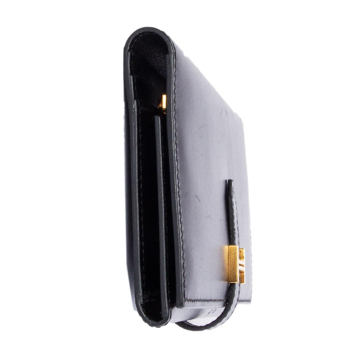 100% authentic Hermes Bearn wallet in black Veau Box leather featuring gold-tone hardware. Opens with a 'H' buckle. Has a zip coin pocket and 10 credit card slots plus 5 flat compartments. Has been carried and is in excellent condition.
