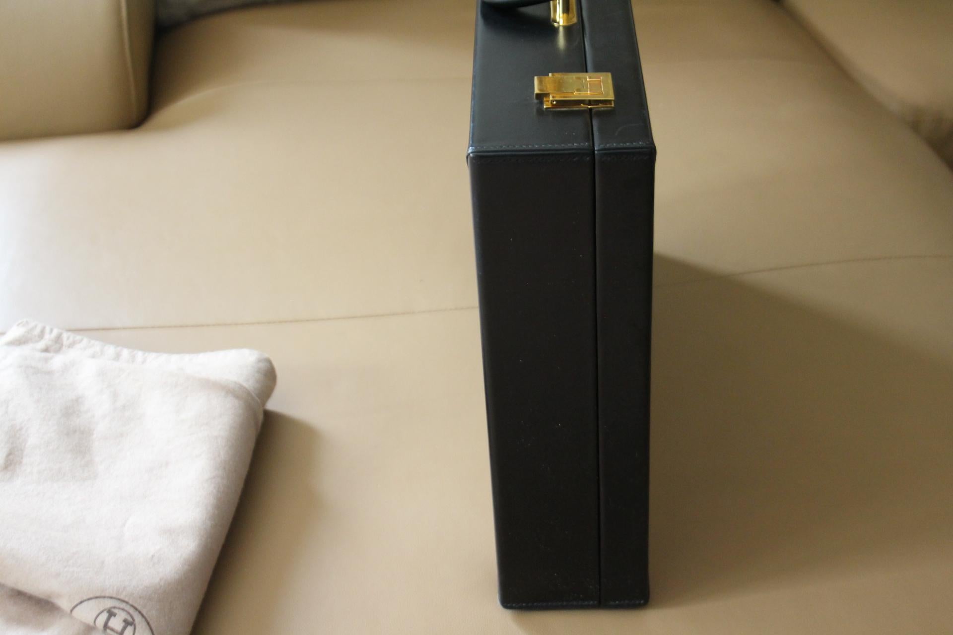 
This elegant Hermès briefcase features black calfskin leather and a comfortable leather handle. Closed by 2 Hermès engraved gold plated solid brass plated latches in the shape of an H as well as a one pinch lock closure , also engraved Hermès.This