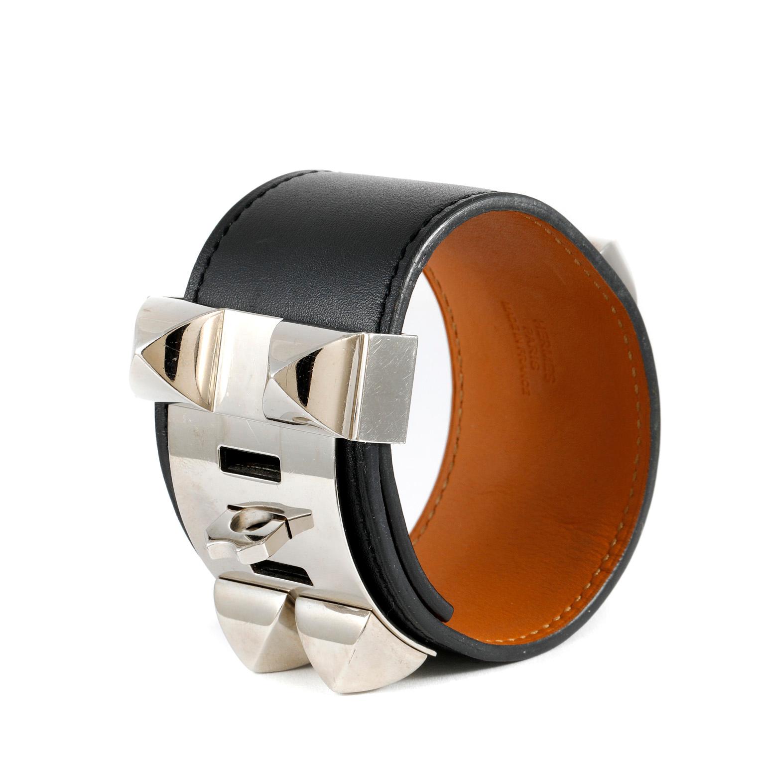 This authentic Hermès Black Leather Collier de Chien Bracelet Cuff is in pristine condition.  The iconic Hermès CDC adds a chic bit of edginess to any ensemble.  Black Swift leather with Palladium Medor pyramid style studs and ring.  Adjustable