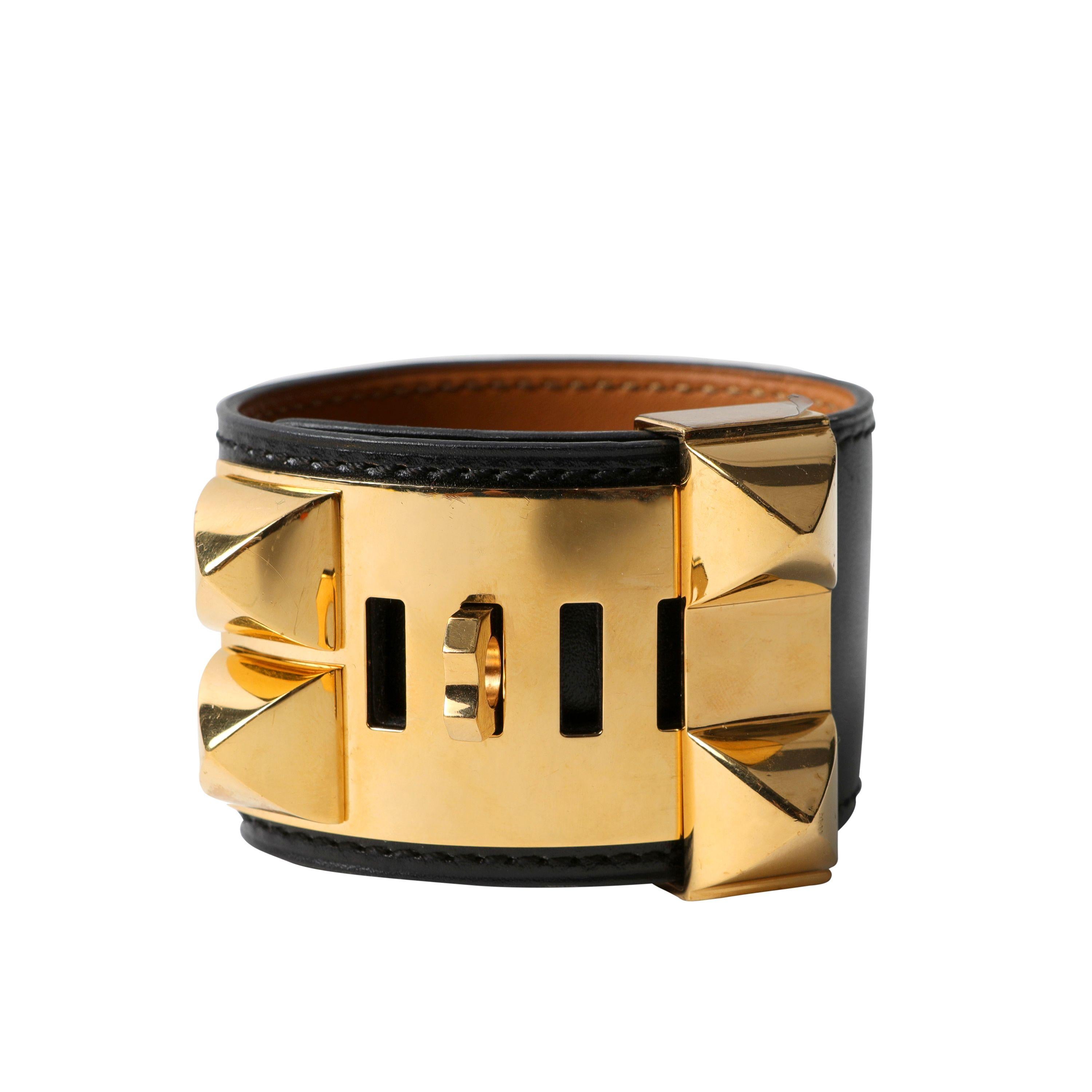 Cet authentique bracelet Hermès Collier de Chien noir est en parfait état.  L'emblématique Icone d'Hermès ajoute une touche de chic à tout ensemble.  Cuir noir avec anneau et clous pyramidaux dorés Medor.  Longueur réglable.  Boîte ou pochette
