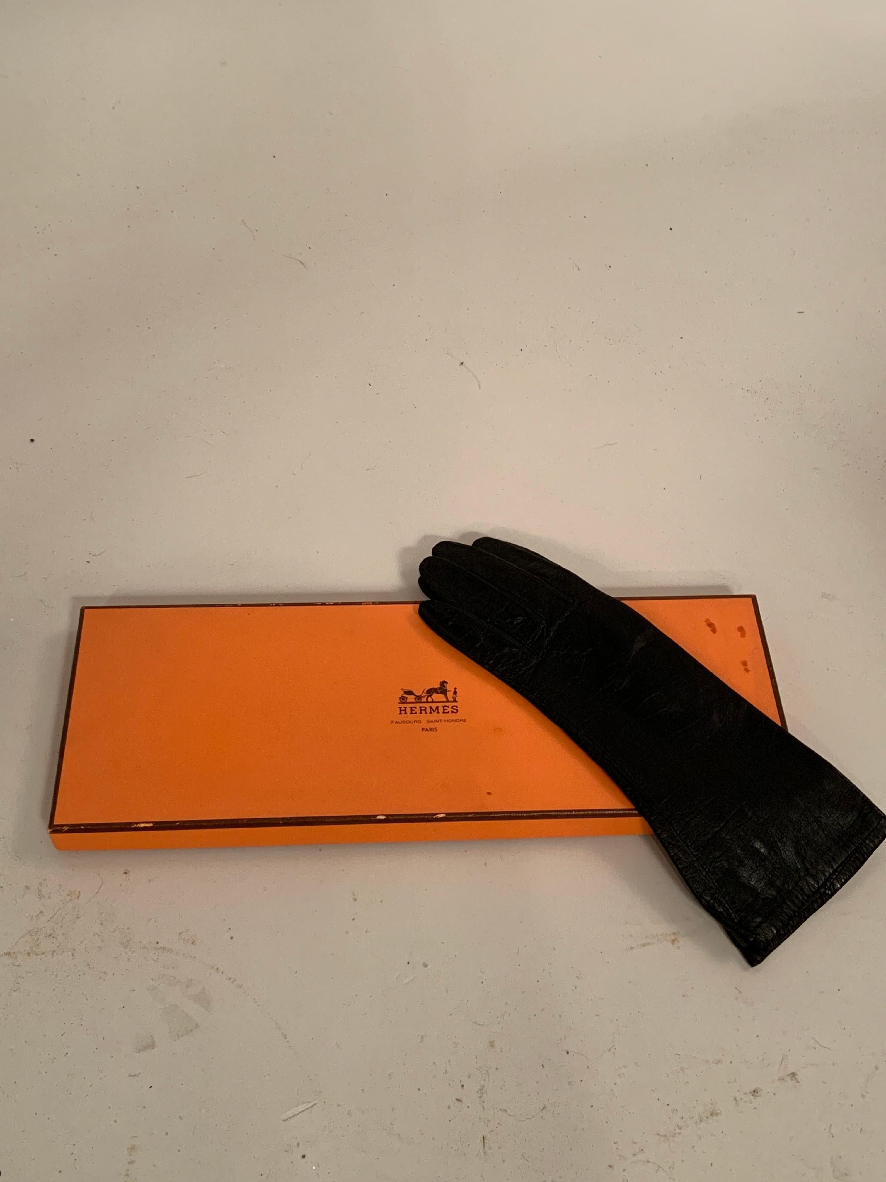 These supple black leather gloves have a white silk lining which bears the Hermes label.  They are in very good condition, marked a size 6 1/2.  If you are unsure of size your glove size is usually the same as your shoe size. These gloves come with
