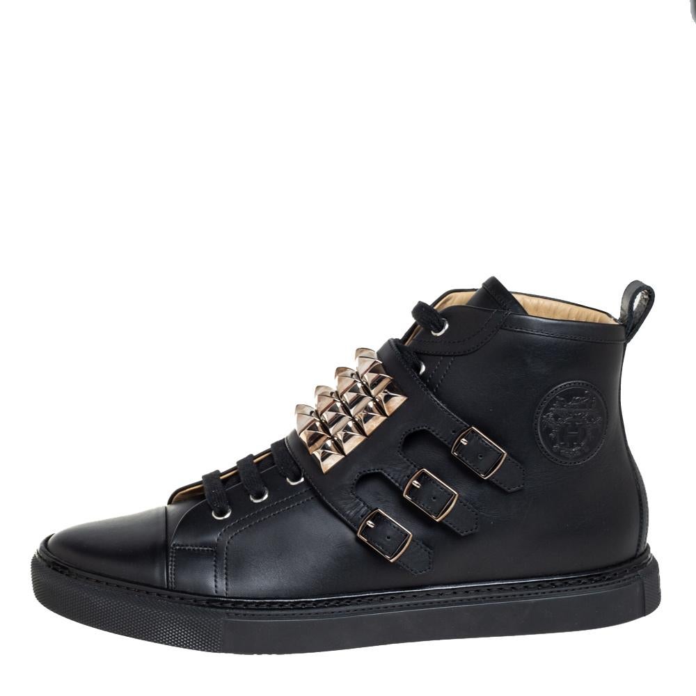 Epitomizing comfort and style, these Hermés Lennox sneakers are made with the utmost skill. Crafted from black leather, they are adorned with broad buckled straps featuring gold-tone pyramid studs, laces, and a high-top silhouette.

Includes: