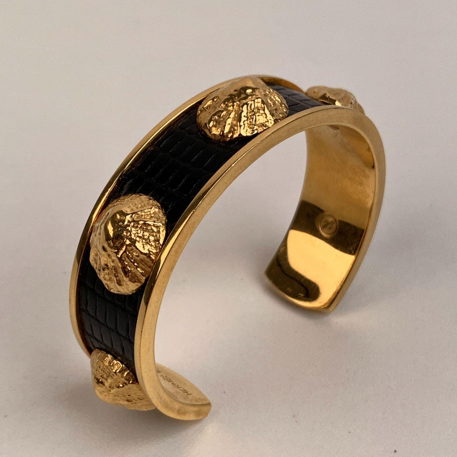 Hermes 'Oyster Shell' Cuff Bracelet. 18k yellow gold-plated brass with oyster shell detailing and black lizard leather inlay. 'Hermes' engraved internally. Max internal diameter: approx. 2 inches - 5,1 cm




Details

MATERIAL: Metal

COLOR: