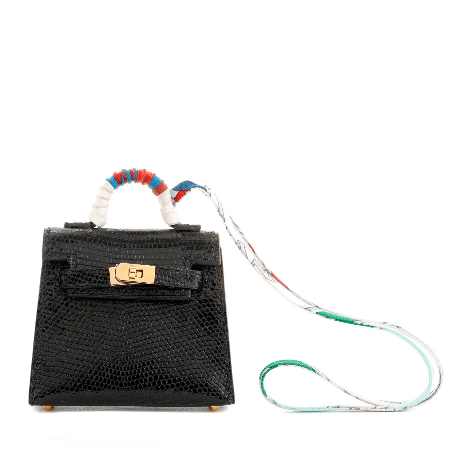 This authentic Hermès Black Lizard Micro Kelly Bag Charm is in pristine condition.  Adorned with a colorful twilly, this tiny exotic Kelly is the ultimate bag charm.  Black lizard skin with gold hardware.  Box and twilly included.

Measurements: 