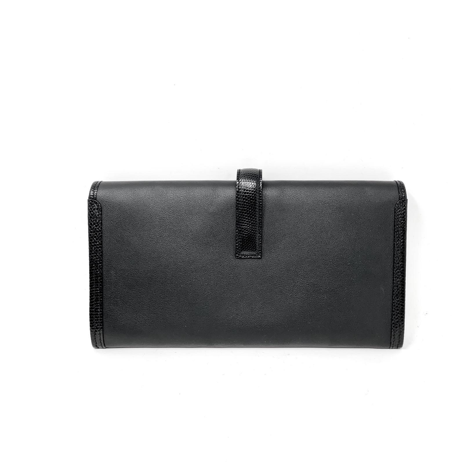 Hermès Black Swift Calfskin Jige Lizard  Elan 29- very Good condition The penultimate clutch for any occasion, it is a must have for any sophisticated wardrobe.  Black smooth Swift calfskin slim clutch has an H belted lizard closure. Black leather