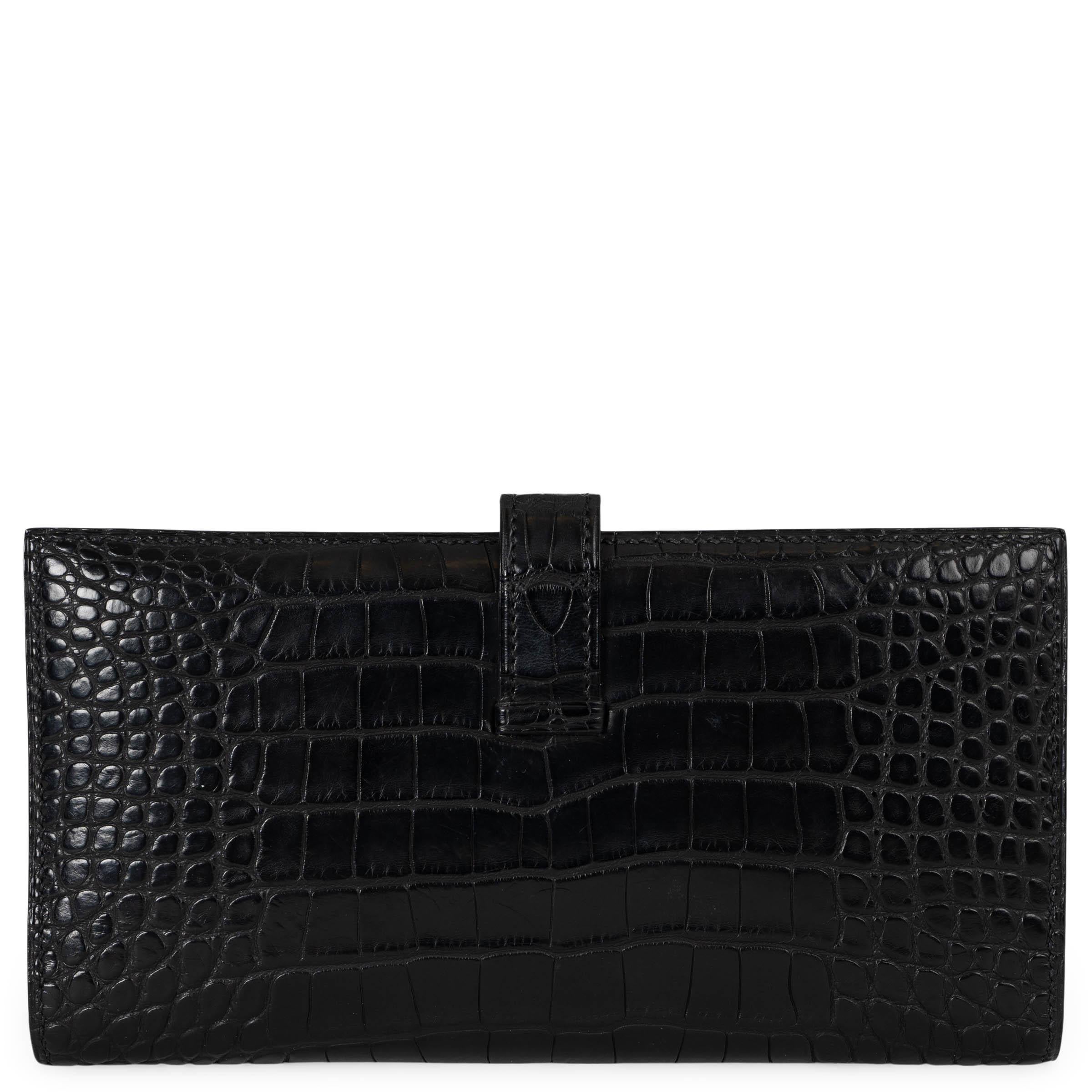 This 100% authentic Hermès Bearn Soufflet wallet in black matte alligator is a timeless statement of luxury and refinement. Featuring an elegant silhouette, it closes with a leather tab and gold-plated openwork H closure. The interior is lined in