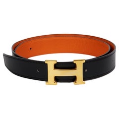 Hermès - Ceinture CONSTANCE en cuir noir et orange - Boucle et lanière réversible en cuir.