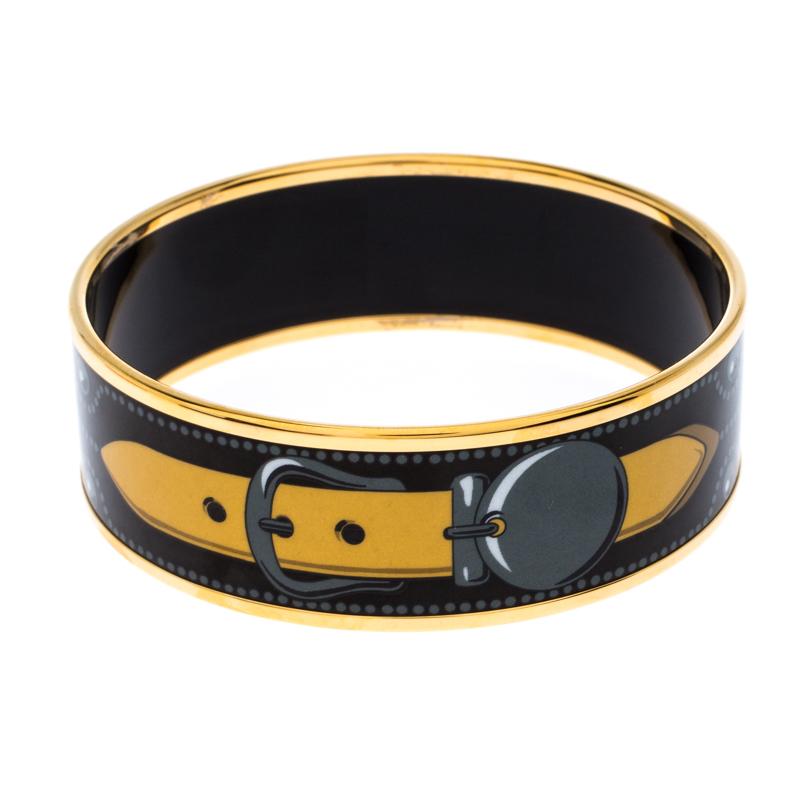 The house of Hermes brings to you a classy piece of jewellery to enhance your style. Crafted elegantly from enamel and gold-tone metal, this bracelet has a colorful print over the black base. This creation is a smart way to make a style statement