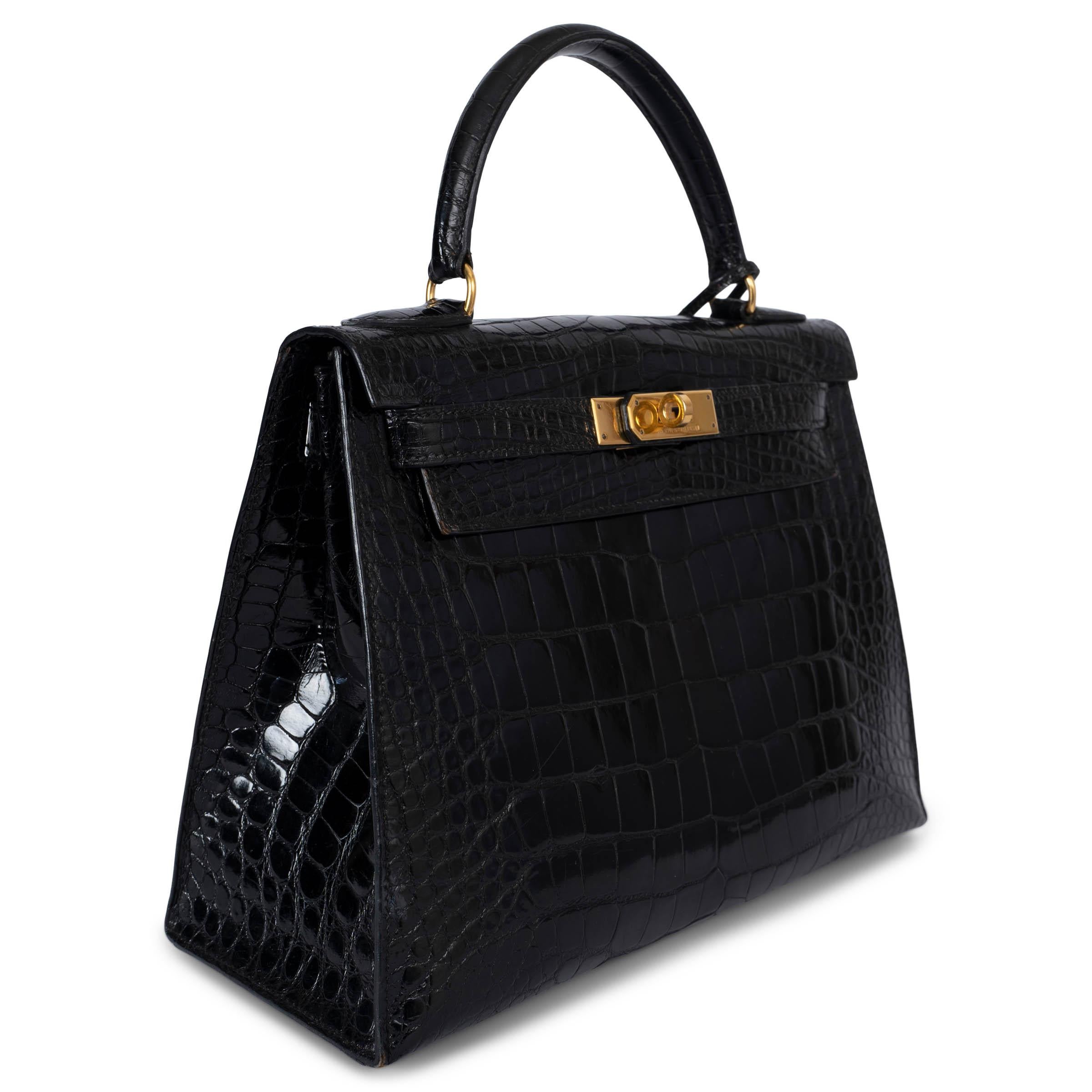 This 100% authentic Hermès Kelly 28 Sellier bag in black shiny Niloticus Crocodile is an extraordinary piece of luxury craftsmanship. Featuring exquisite gold-tone hardware that complements the deep, lustrous finish, this bag embodies timeless