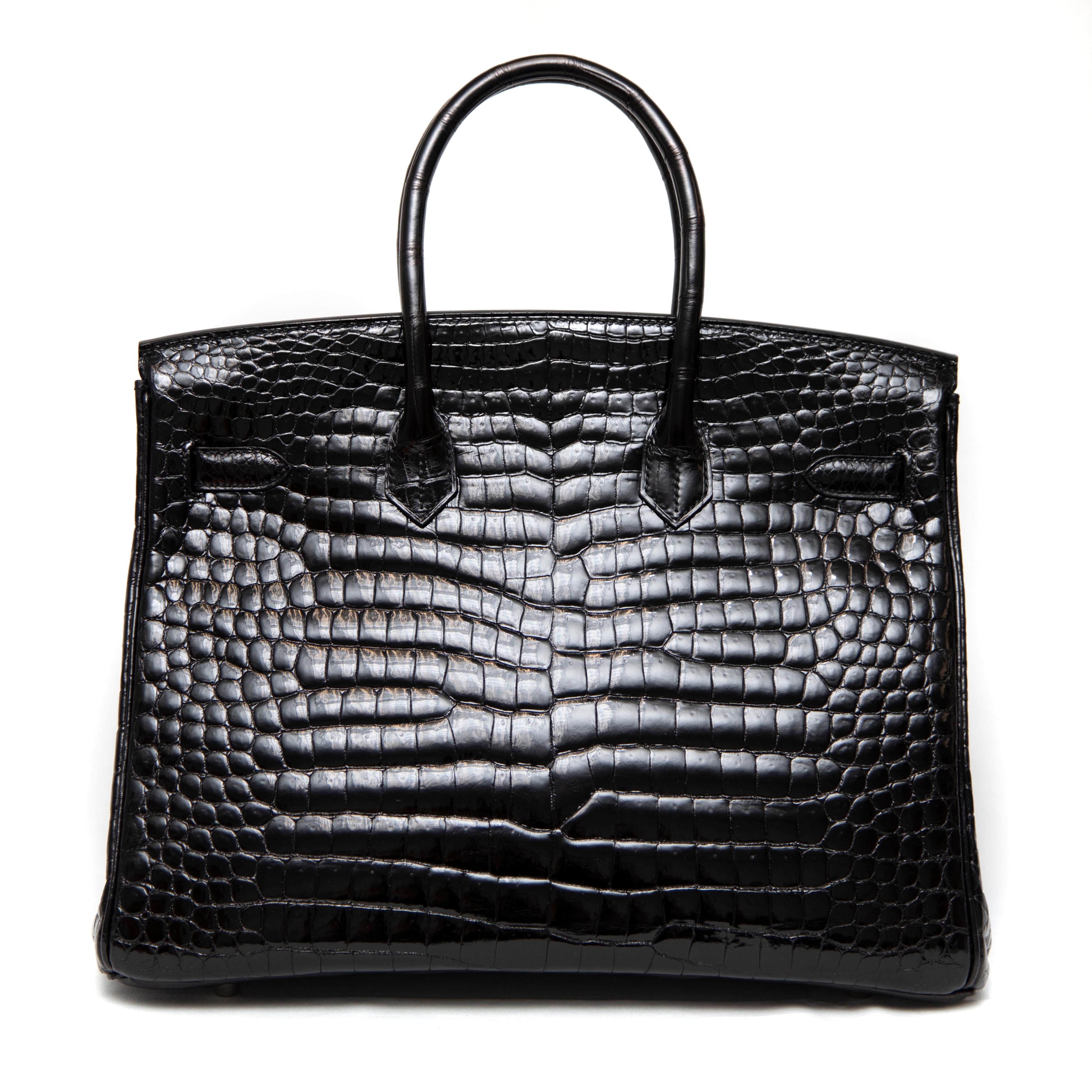 This exquisite Hermès Birkin 35CM is crafted from luxurious black shiny Porosus crocodile leather, known for its highly sought-after and beautifully symmetrical scale pattern. The high-gloss finish enhances the richness of the deep black hue,