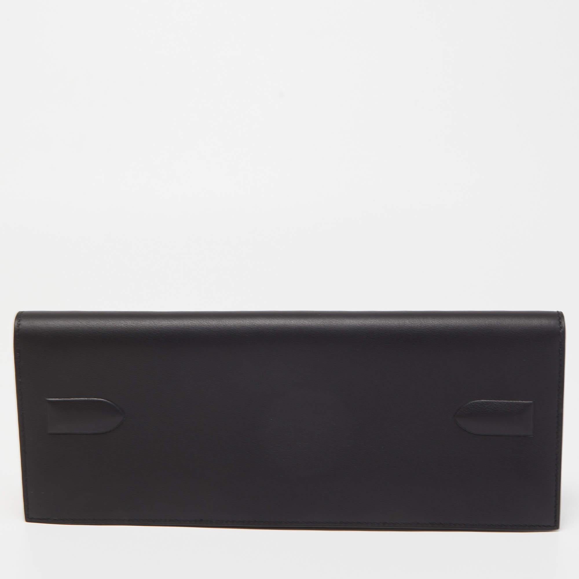 The Hermès Shadow Kelly clutch exudes elegance and sophistication. Crafted from luxurious black Swift leather, it features the iconic Kelly bag silhouette in a compact clutch form. The sleek design is accentuated by clean lines, making it a timeless