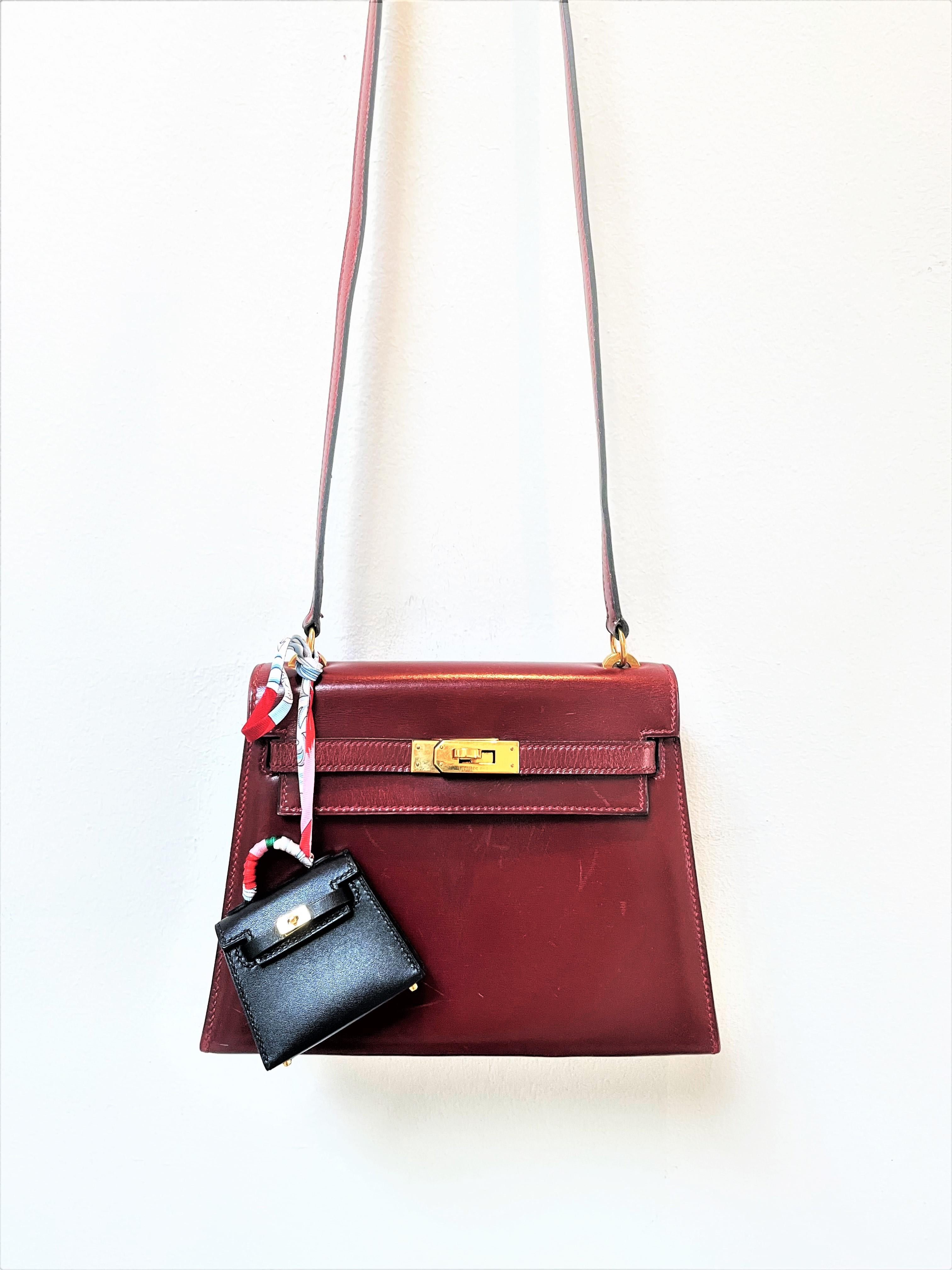 À propos de
Mini sac Kelly HERMÈS en cuir Tadelakt noir et ruban de soie multicolore Twill Breloque, tonalité dorée Quincaillerie. 
Il s'agit d'un sac à breloques 