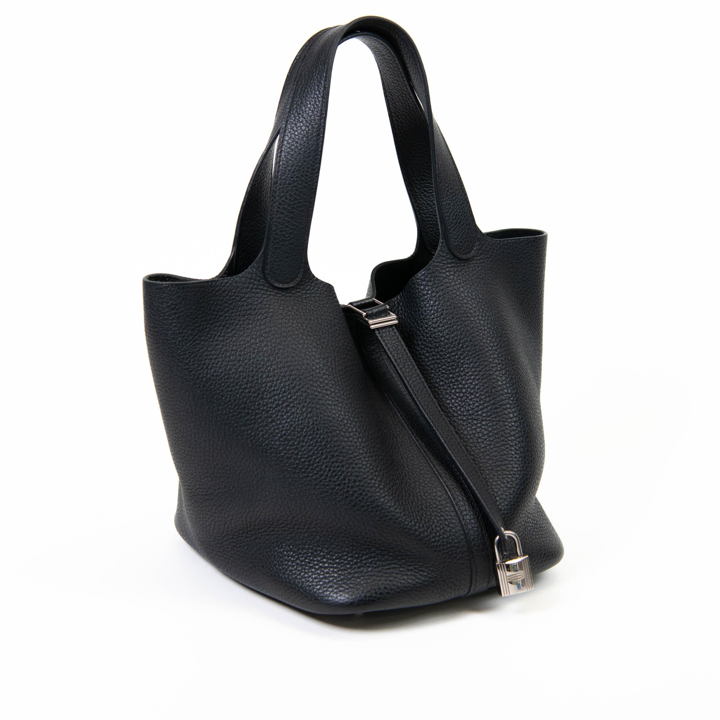 100% Authentic

This chic and lovely tote is crafted of luxuriously soft Clemence calfskin leather in black. The bag features looping leather top handles and silver-plated hardware, including a lock and keys. The top strap opens to a spacious black