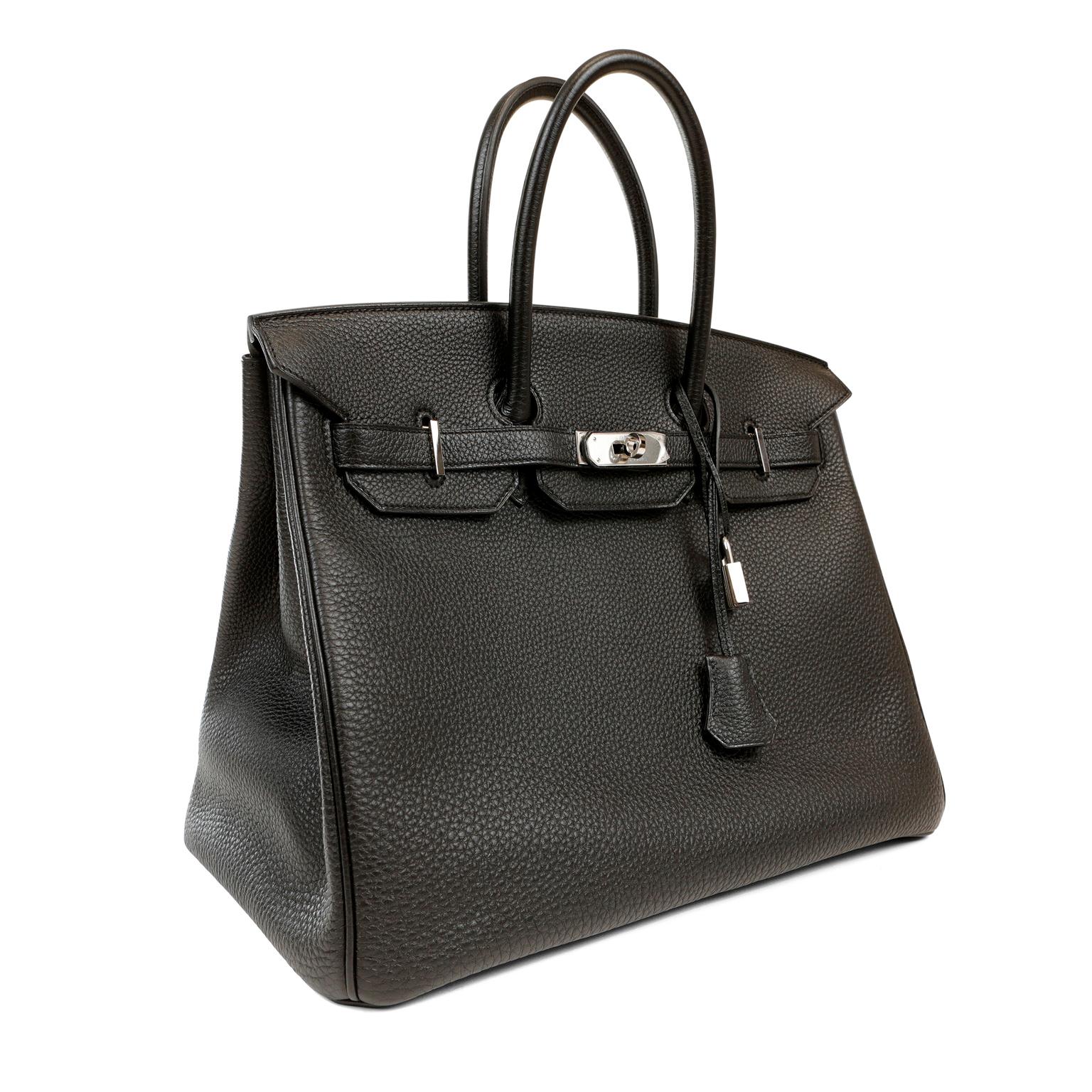 Cet authentique Hermès Black Togo 35 cm Birkin est en parfait état avec le plastique de protection intact sur une grande partie du matériel.    Cousu à la main par des artisans qualifiés, les listes d'attente d'un an ou plus sont courantes pour le