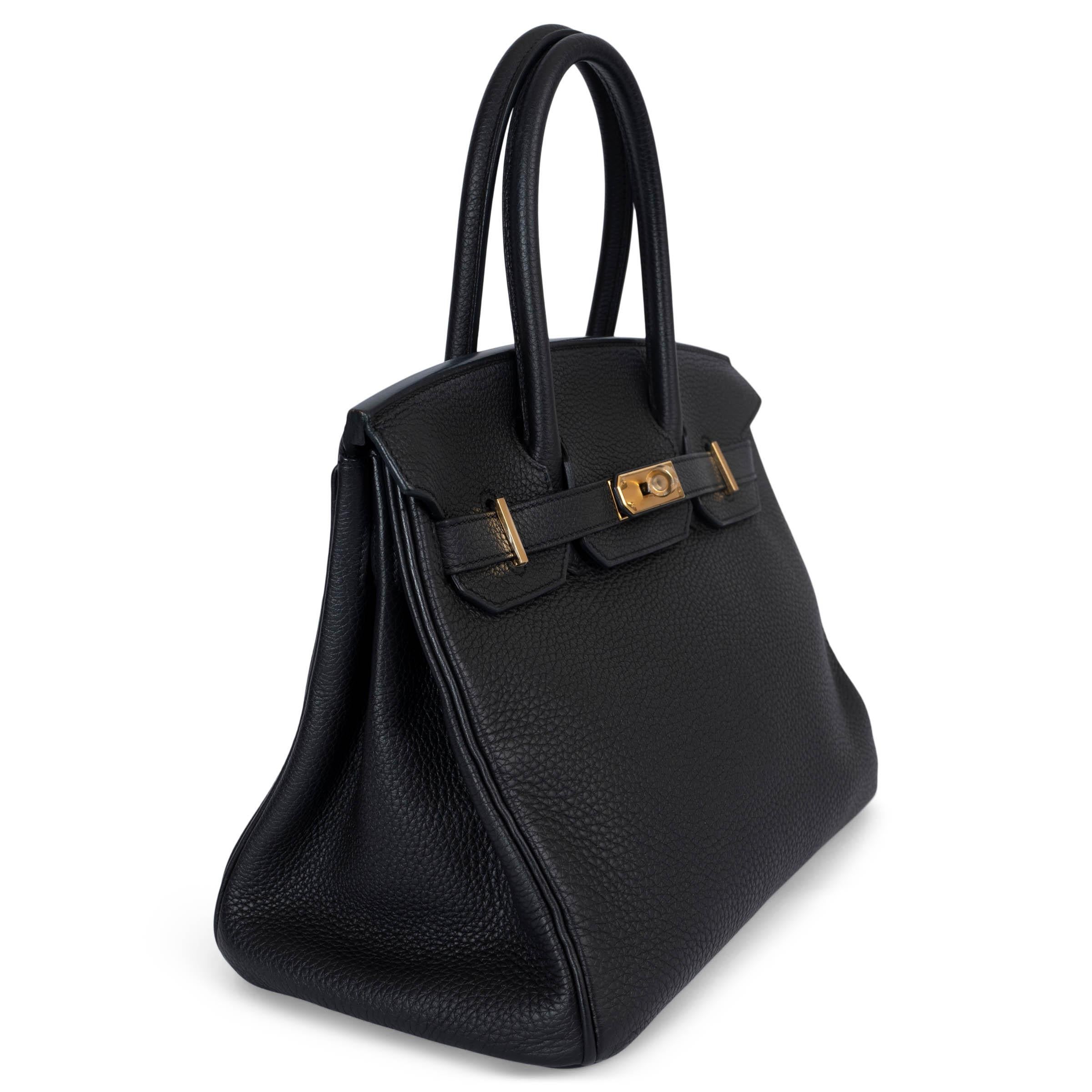 This 100% authentic Hermès Birkin 30 bag is crafted from luxurious black Veau Togo leather, showcasing elegant gold-plated hardware. The interior is lined in Chèvre (goat skin) and features an open pocket against the front and a zipper pocket