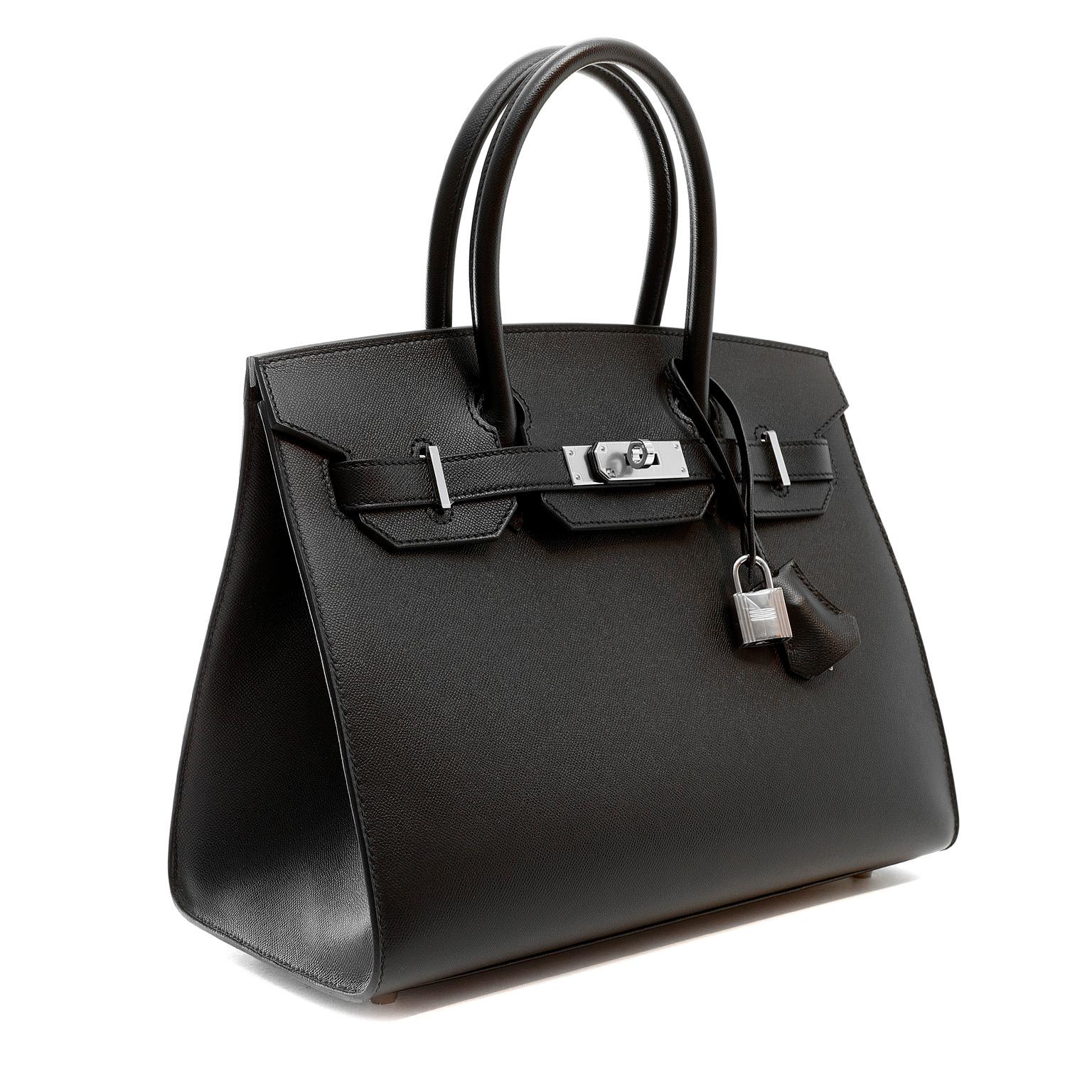 This authentic Hermès Black Veau Madame 30 cm Sellier Birkin is in pristine unworn condition; the protective plastic is still intact on the hardware.    Considered the ultimate luxury item, the Hermès Birkin is stitched by hand. 
Veau Madame leather