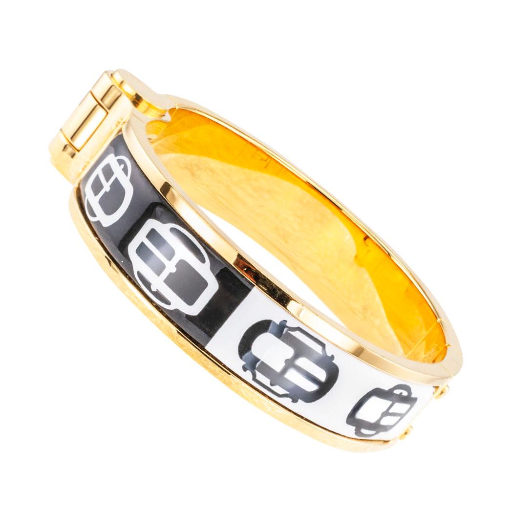  Hermes black and white enamel buckle motif hinged bangle bracelet yellow gold plated with clasp on the top half of the bangle bracelet.

SPECIFICATIONS: 

METAL:  yellow gold plated bangle decorated with black and white enamel.

HALLMARKS:  Hermes