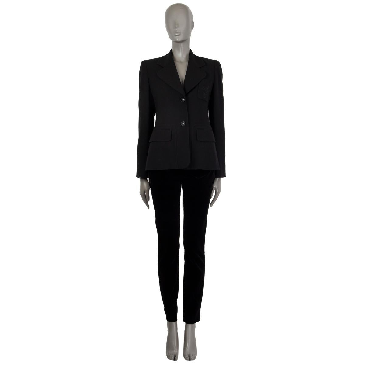 Hermes blazer in black wool (100%). With wide notch collar, chest pocket with brand insignia, two flap pockets on the front sides, two slit on the back, and one-button sleeves. Closes with black H buttons on the front. Lined in black pin-striped