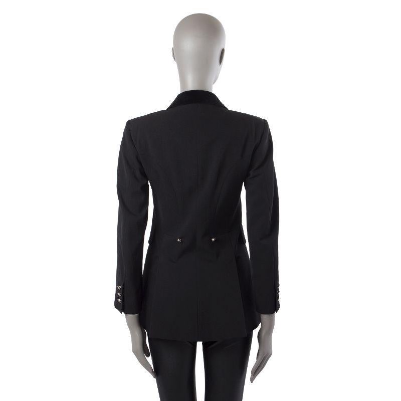Hermes long blazer in black wool (100%). With velvet notch collar, two front flap pockets, two silver-tone buttons on the back, and two back slits. Closes with silver-tone buttons on the front and cuffs. Lined in black polyester (100%). Has been