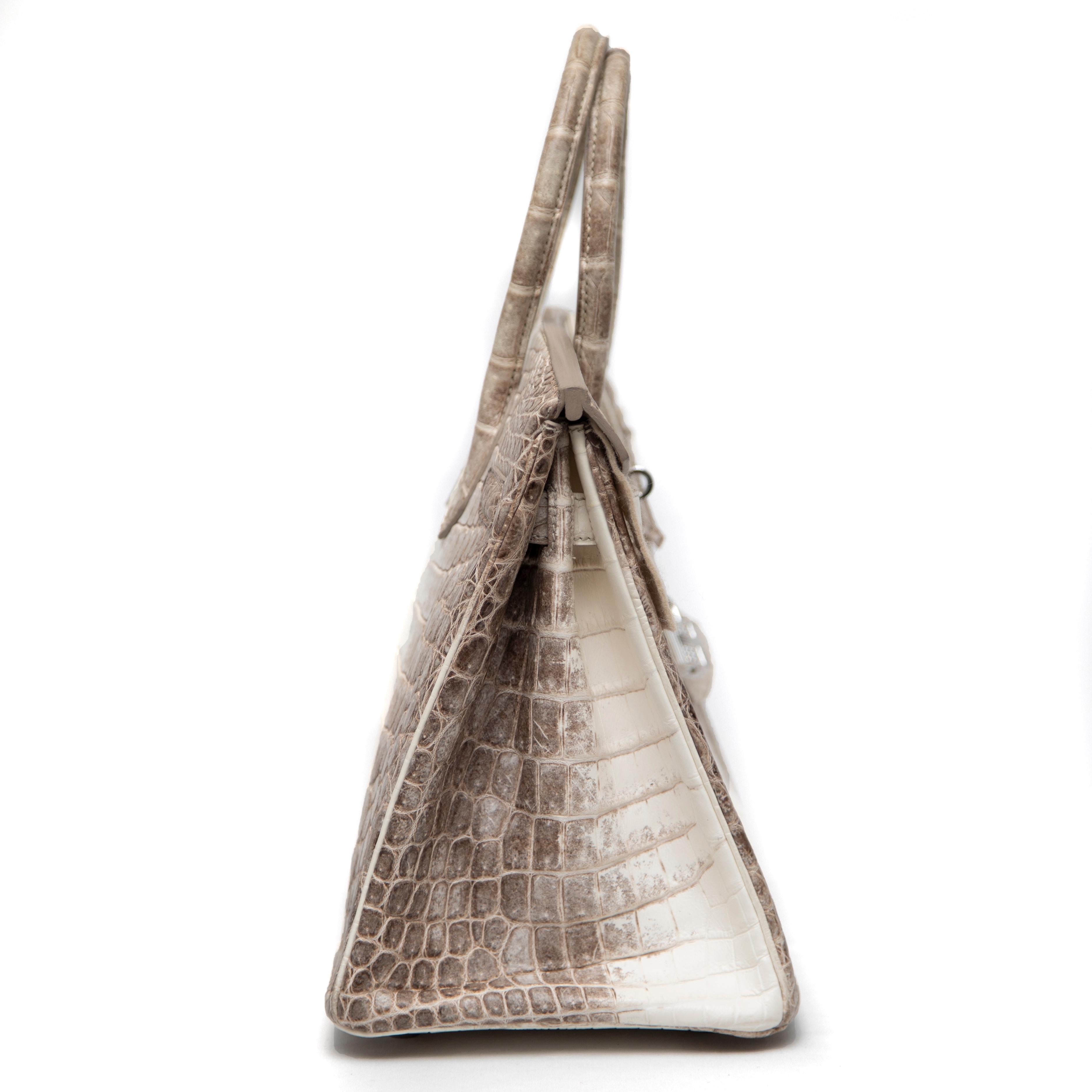 Als Meisterwerk des Luxus und der Handwerkskunst ist diese Hermès Birkin 30CM aus dem seltenen Himalaya-Niloticus-Krokodilleder gefertigt, das für seinen atemberaubenden Farbverlauf von zartem Weiß zu rauchigem Grau bekannt ist. Diese begehrte