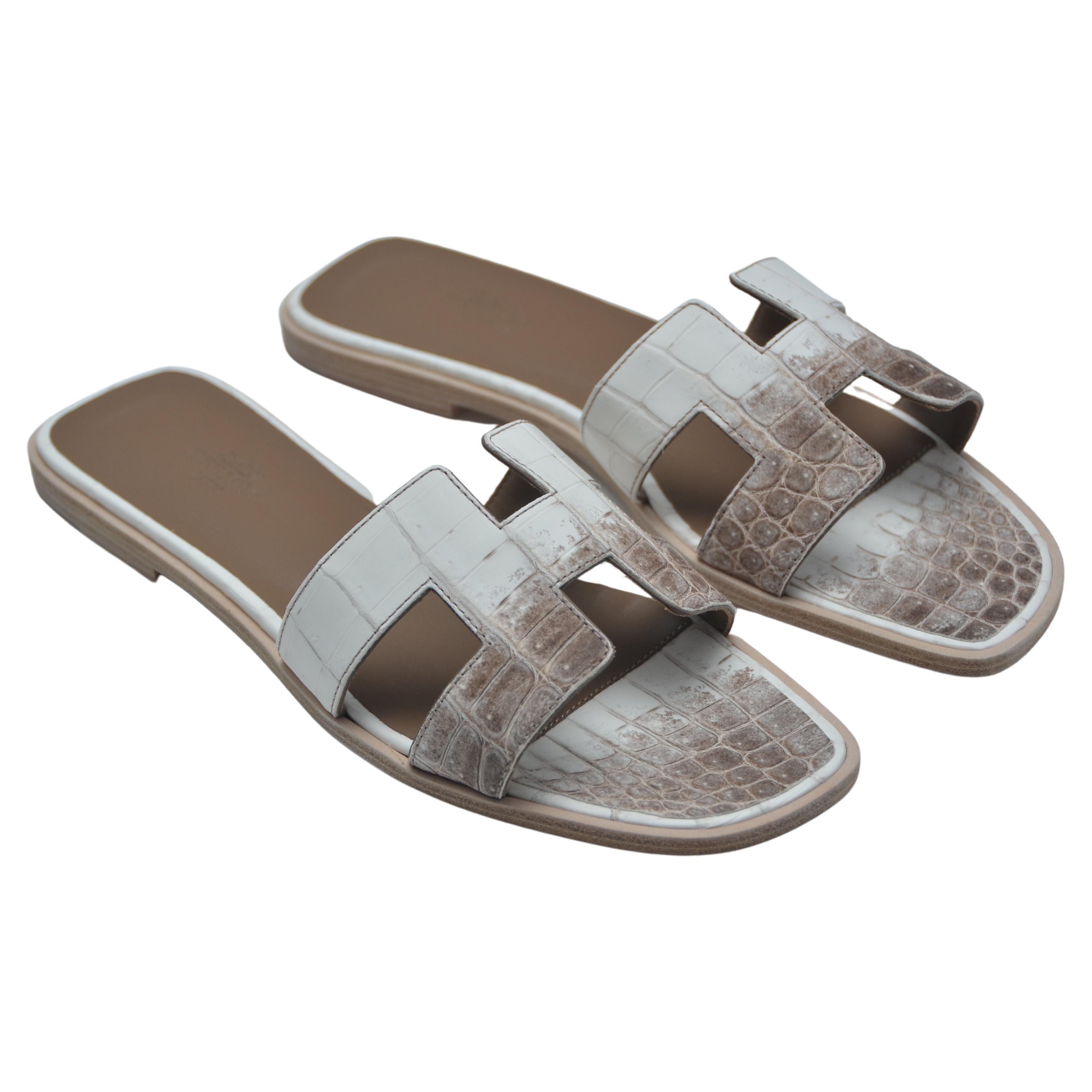 100% authentic guaranteed 
HERMES NEW Blanc/Noisette  Niloticus Crocodile Himalaya Oran Slides Sandals
Size 39
NEW with dust-bags, ribbon ,Cites, booklet  and Hermes box .Some shipping restrictions apply since these are crocodile .
Made In
