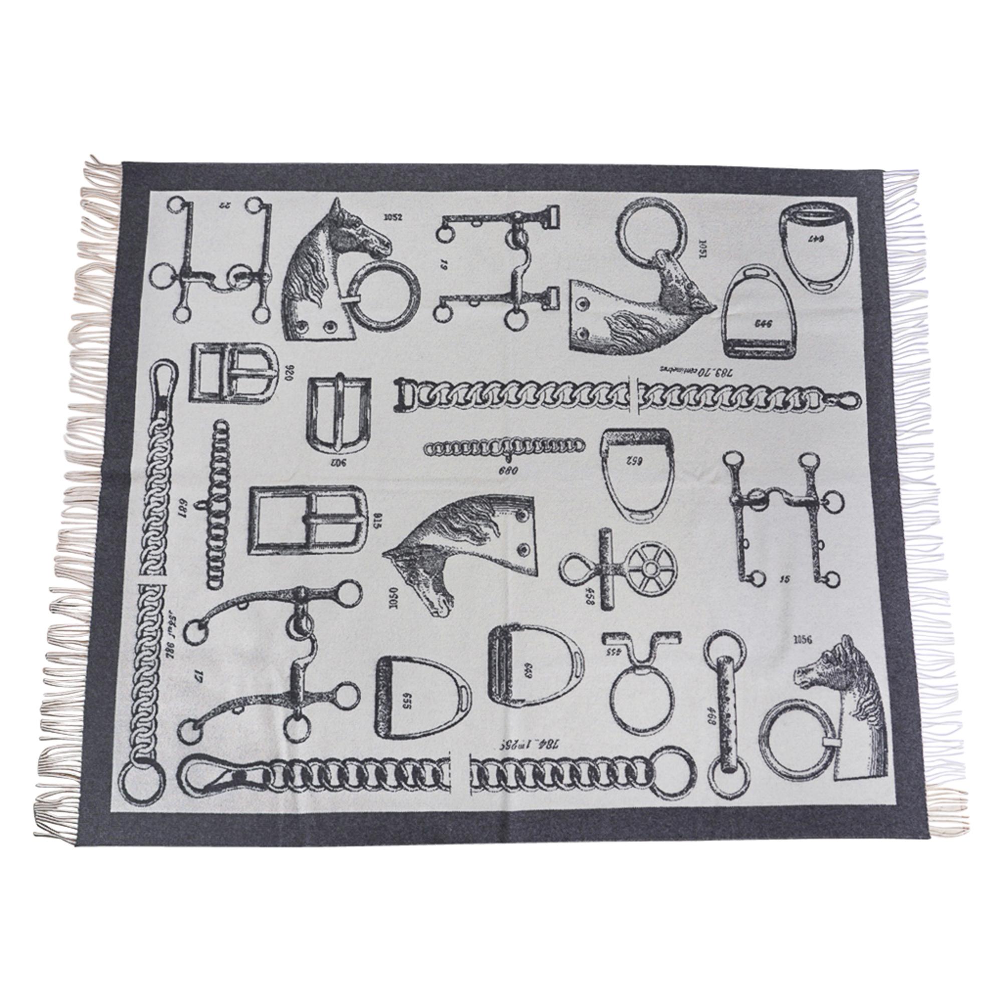 Mightychic offers a rare Hermes limited edition Metalleries reversible blanket featured in Gris and Ecru.
Detailed equestrian objects adorn the fringed edged Hermes Blanket.
Created from 72% Cashmere and 90% Wool this wonderfully warm blanket is a