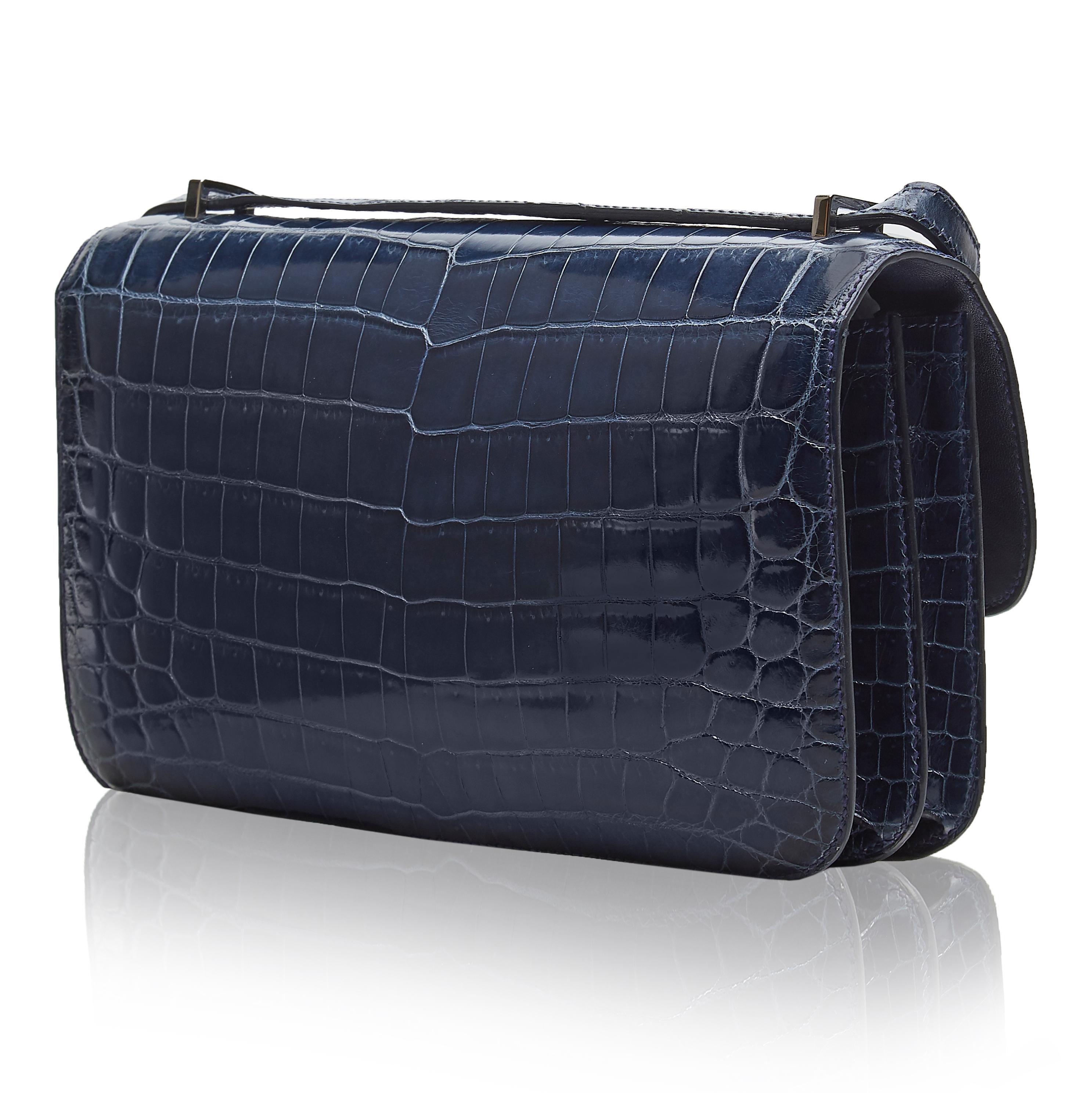 This 25cm Constance Elan shoulder bag from Hermès was meticulously crafted in France from a highly precious Niloticus crocodile in a deep shade of navy blue. Offset with silver-tone palladium-plated hardware, its slender body is adorned with the