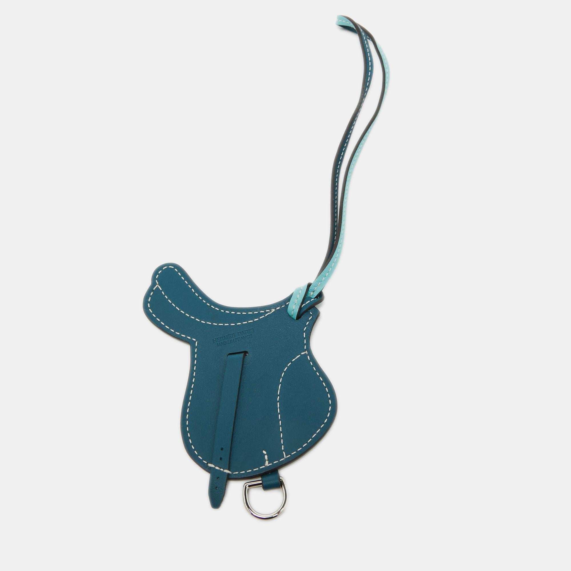 The Hermès Paddock Selle bag charm is an exquisite accessory crafted from luxurious Swift Leather. Its design features a luxe shade. This charming piece perfectly complements any Hermès bag, adding a touch of elegance and sophistication.

