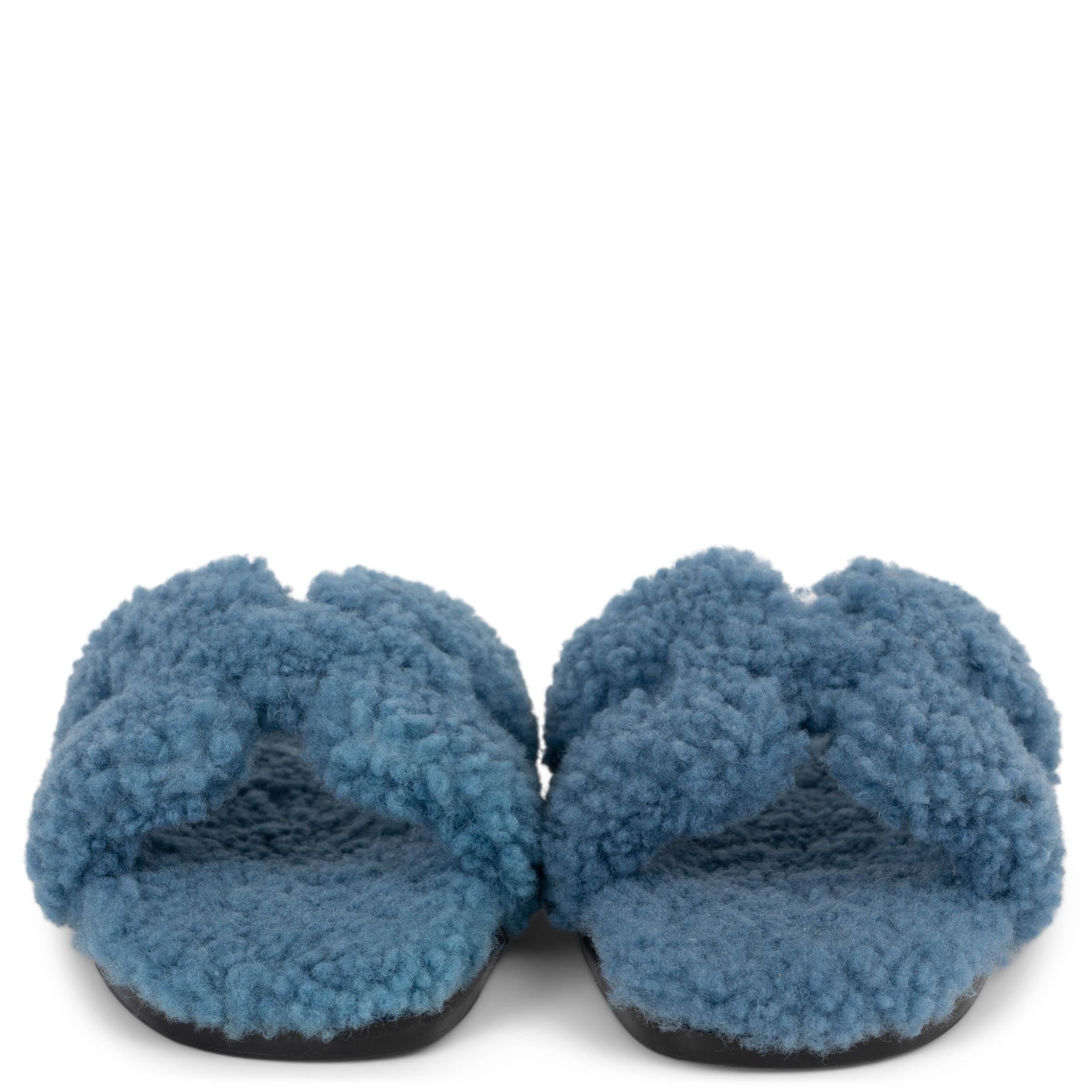 Diese 100% authentischen Hermès Oran-Teddy-Sandalen aus Wollleder in Bleu sind eine luxuriöse Interpretation des ikonischen Designs der Marke. Sie sind aus ultraweichem Wollleder gefertigt und verfügen über den charakteristischen 