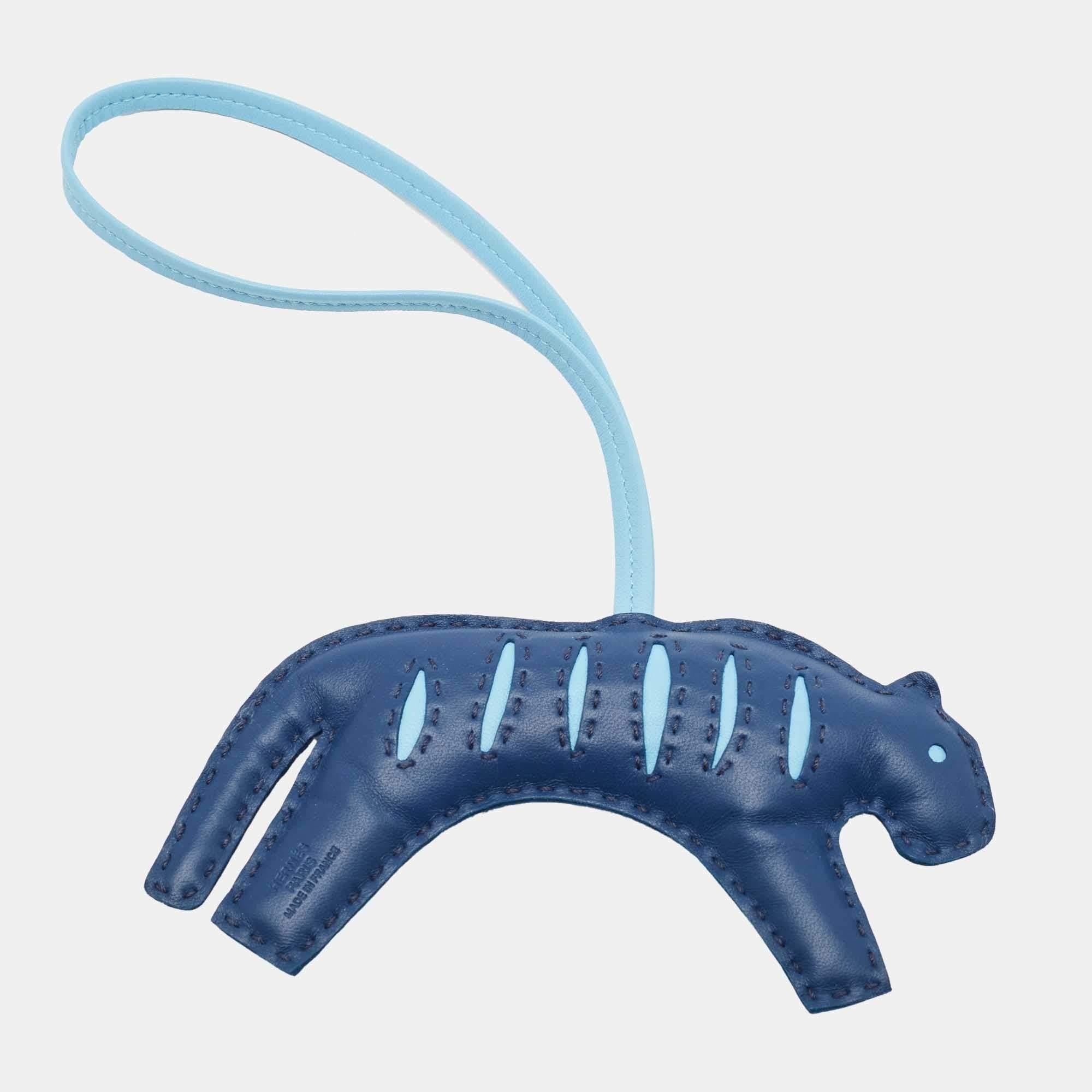Add a signature touch to your luxury handbag collection with this stunning RooRoo bag charm from the House of Hermes. This leather charm can effortlessly complement your Birkin or Kelly bag. It is truly a collector's delight!

