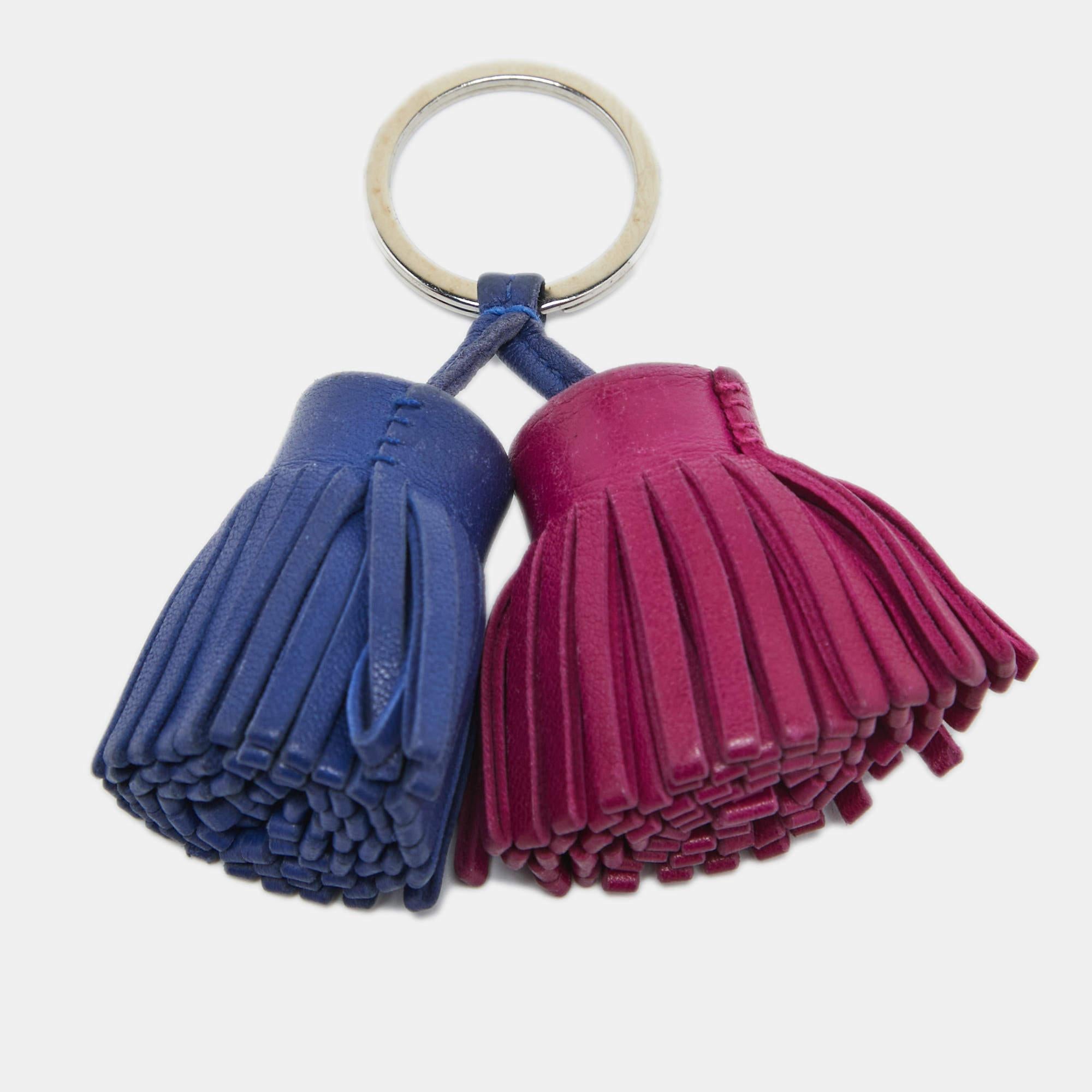 The Hermès Carmen key chain is a stylish accessory that adds a touch of luxury to your everyday essentials. Crafted from leather, it features two tassels and a metal ring to hold your keys.