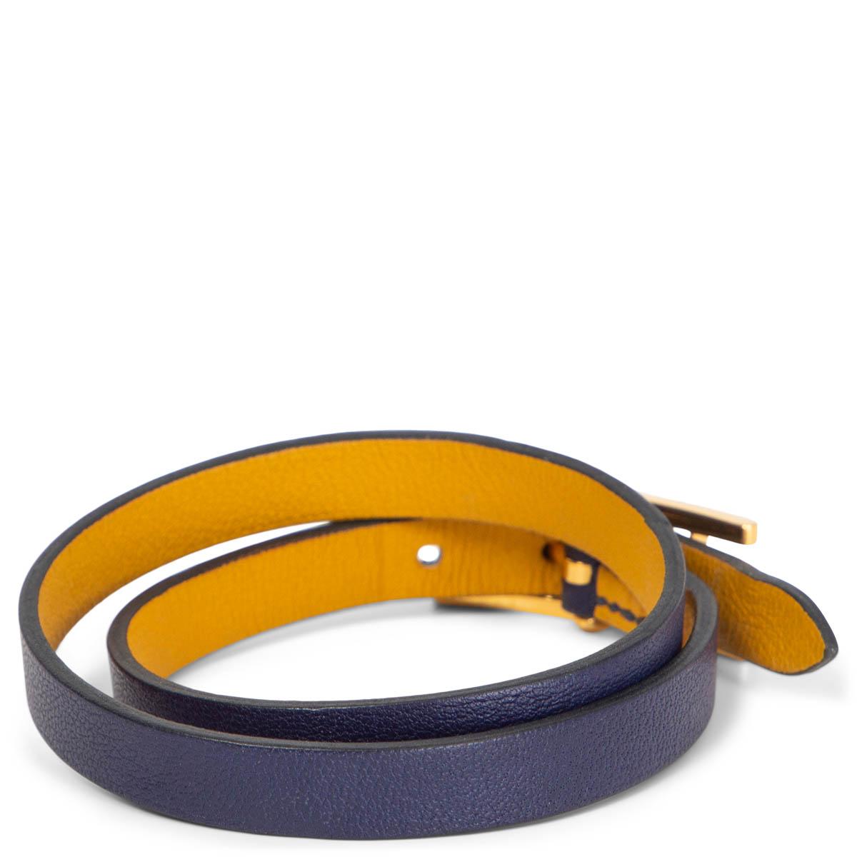 Bracelet double tour 100% authentique Hermès Behapi en cuir Swift bleu Encre et jaune Ambre. Le bracelet est une longue bande de cuir de veau swift bleu foncé qui s'enroule deux fois autour du poignet et se ferme avec une boucle Hermès H plaquée or.