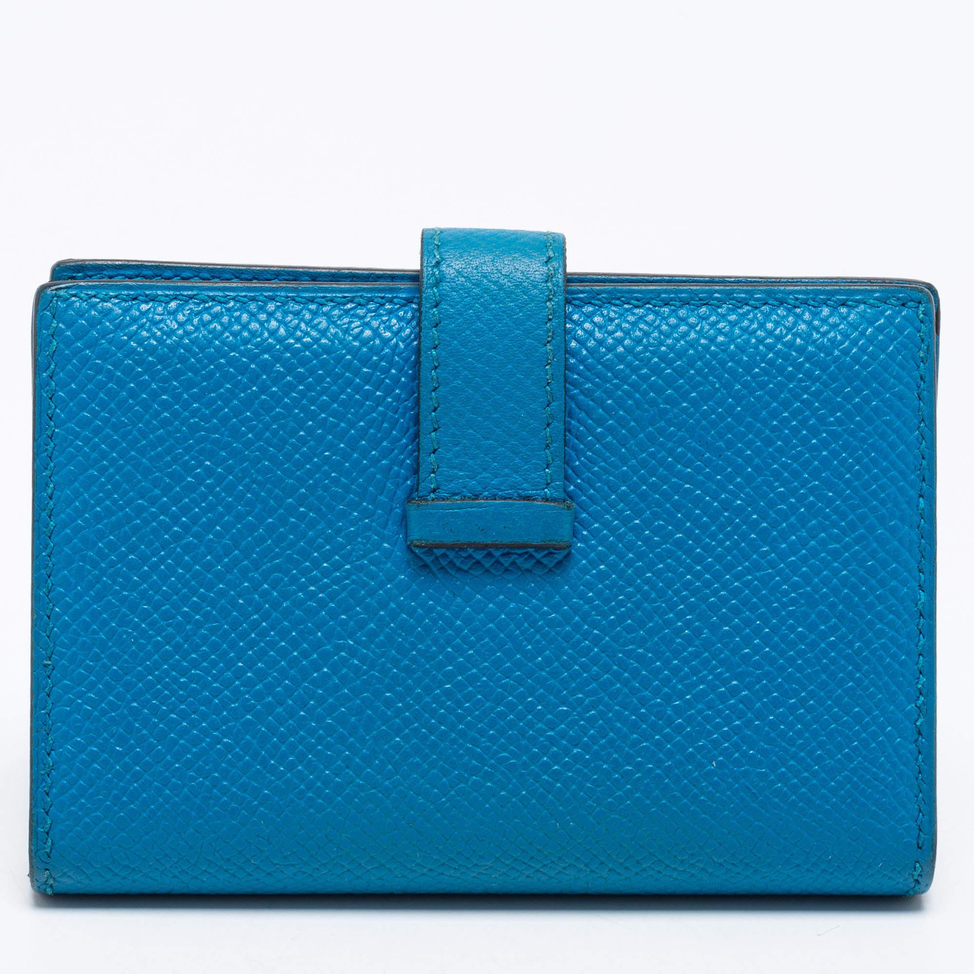Luxuriously crafted by the experts at Hermès, this stunning Bearn wallet is a special accessory. Presented in Bleu Izmir Epsom leather, this wallet features a silver-tone H where the strap can be tucked in and opened to reveal leather-lined