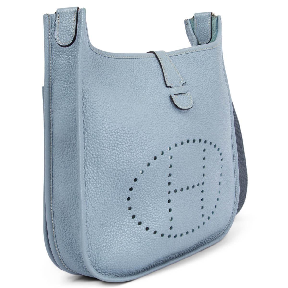 100% authentic Hermes Evelyne III 29 crossbody bag in Bleu Lin (baby blue) Taurillon Clemence leather with contrasting ivory stitching. Adjustable canvas shoulder strap. Open pocket on the back. Closes with a snap button on top. Unlined. Has been