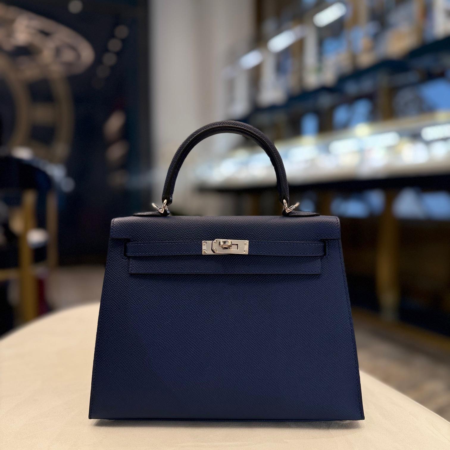 Jewels Aficionado offers an Hermès Bleu Navy Kelly Sellier 25 in Epsom leather that is a sleek and sophisticated piece. Its deep navy hue enhances the structured Sellier silhouette, while Epsom leather ensures durability and a crisp shape. Finished