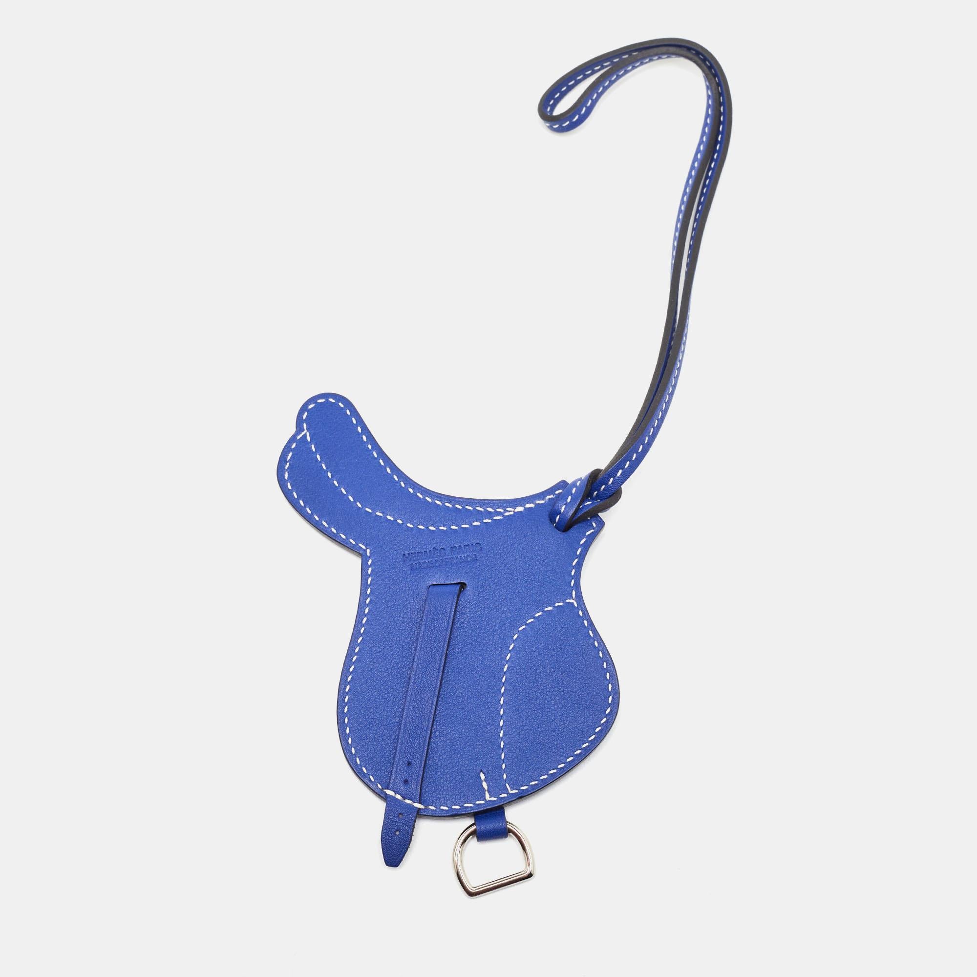 The Hermès Paddock Selle bag charm is an exquisite accessory crafted from luxurious Swift Leather. Its design features a luxe blue shade. This charming piece perfectly complements any Hermès bag, adding a touch of elegance and sophistication.

