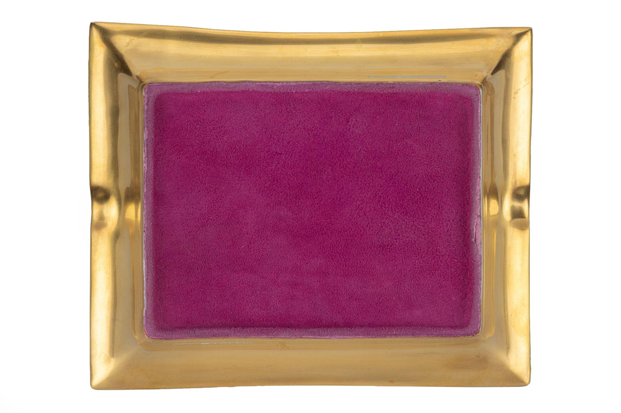 Questo posacenere firmato Hermès con il disegno di un uccello blu in arancione e oro. Fondo stampato in pelle scamosciata. Prodotto in Francia. Edizione speciale con lamina inferiore. Nessuna scatola.